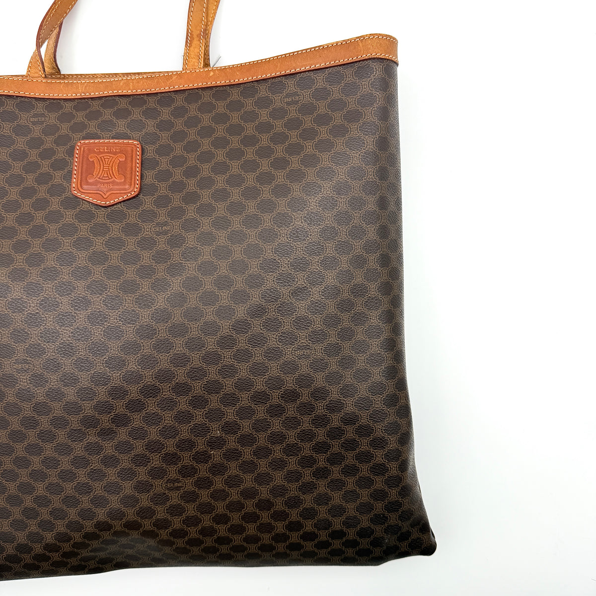 Front view of the Celine Triomphe Macadam Tote Bag in brown coated canvas with tan leather detailing and double handles.