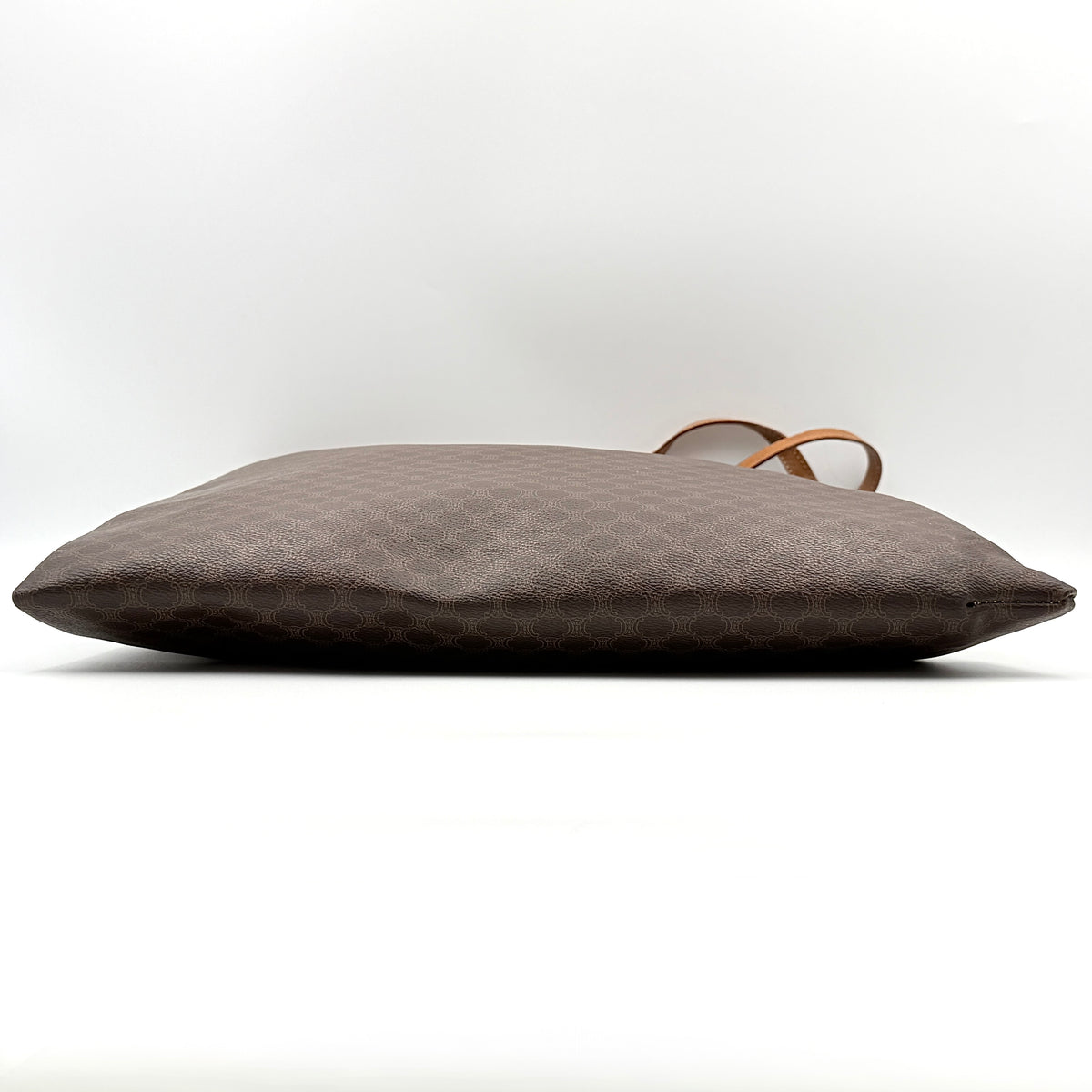 Front view of the Celine Triomphe Macadam Tote Bag in brown coated canvas with tan leather detailing and double handles.