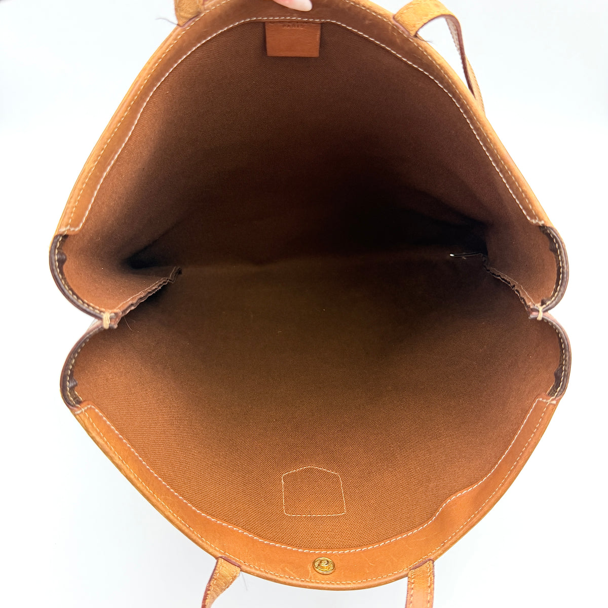 Front view of the Celine Triomphe Macadam Tote Bag in brown coated canvas with tan leather detailing and double handles.