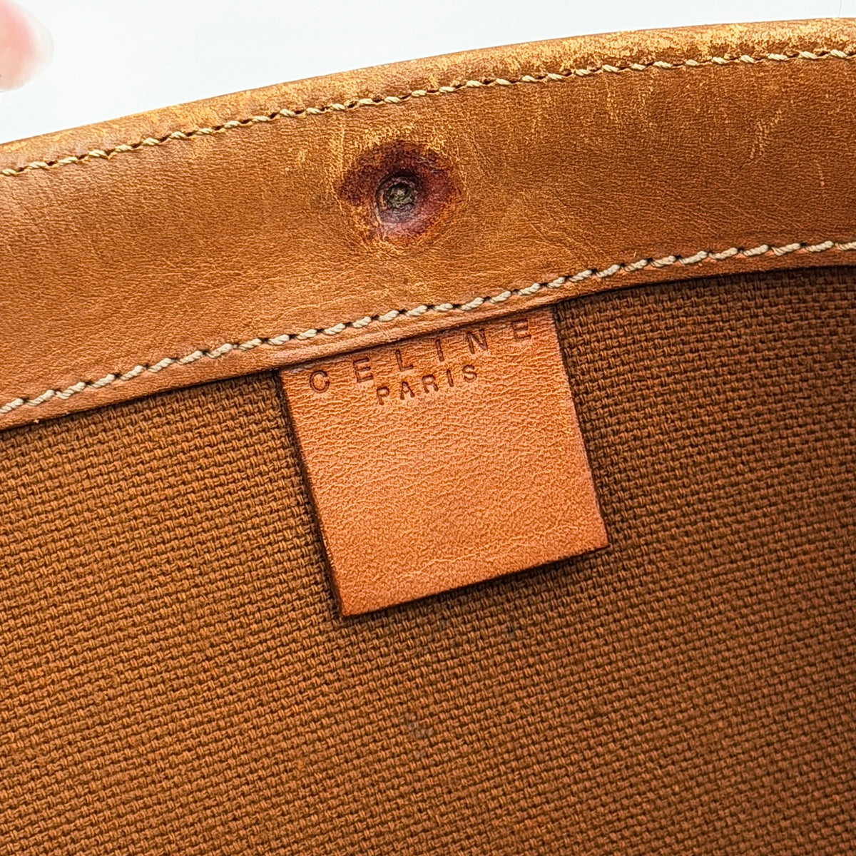 Front view of the Celine Triomphe Macadam Tote Bag in brown coated canvas with tan leather detailing and double handles.
