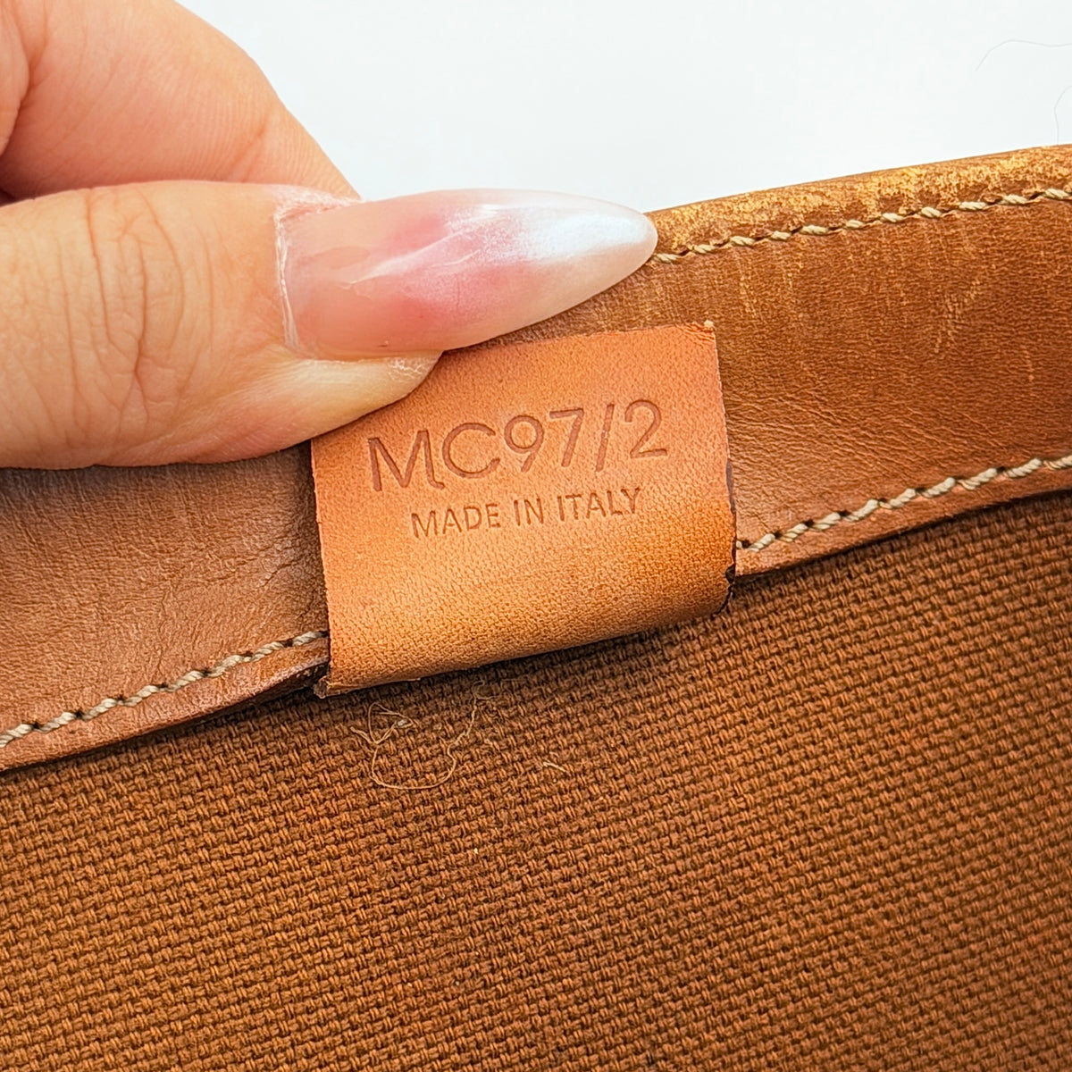 Front view of the Celine Triomphe Macadam Tote Bag in brown coated canvas with tan leather detailing and double handles.