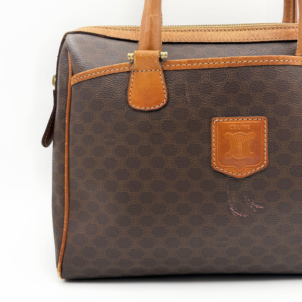 Celine Triomphe Macadam Boston Bag in brown coated canvas with tan leather trim and top handles, photographed against a white background.