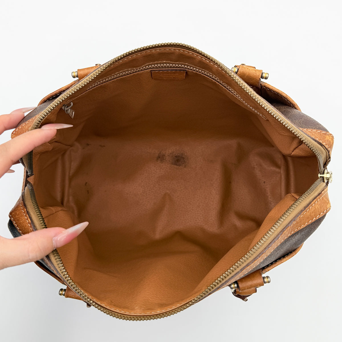 Celine Triomphe Macadam Boston Bag in brown coated canvas with tan leather trim and top handles, photographed against a white background.