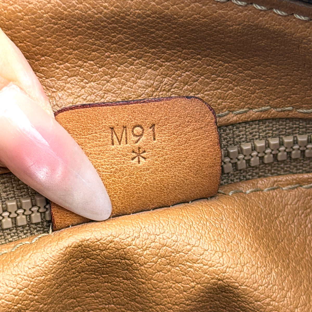 Celine Triomphe Macadam Boston Bag in brown coated canvas with tan leather trim and top handles, photographed against a white background.