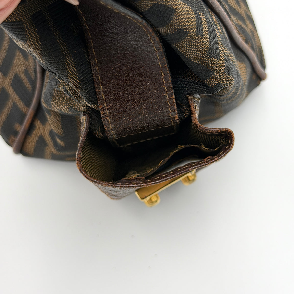 Fendi FF Zucca Double Zip Tote Bag in brown monogram canvas with leather straps and side pocket detail, shown on a yellow dust bag.