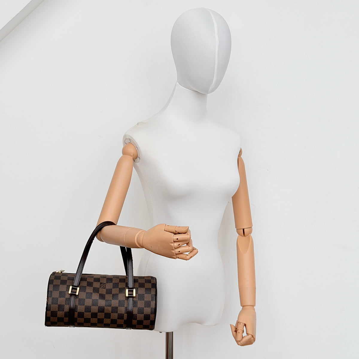 Louis Vuitton Damier Ebene Papillon 26 handbag in brown checked canvas with chocolate leather handles and gold hardware against a white background.