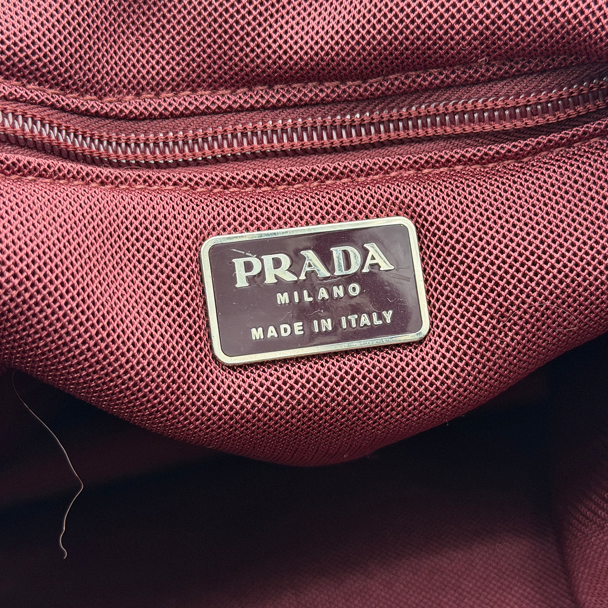 Prada pink nylon tote bag with berry handles photographed against a white background.
