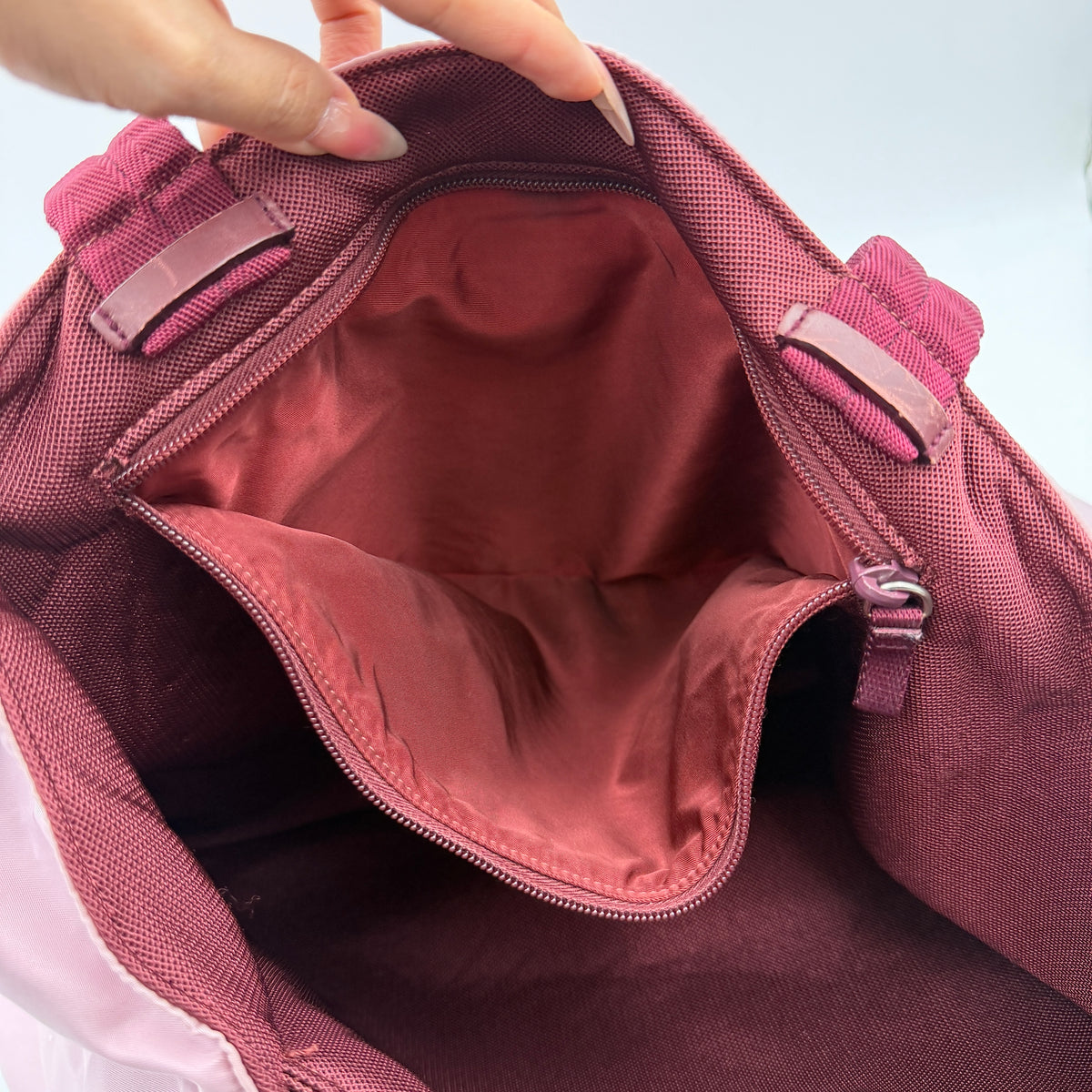 Prada pink nylon tote bag with berry handles photographed against a white background.