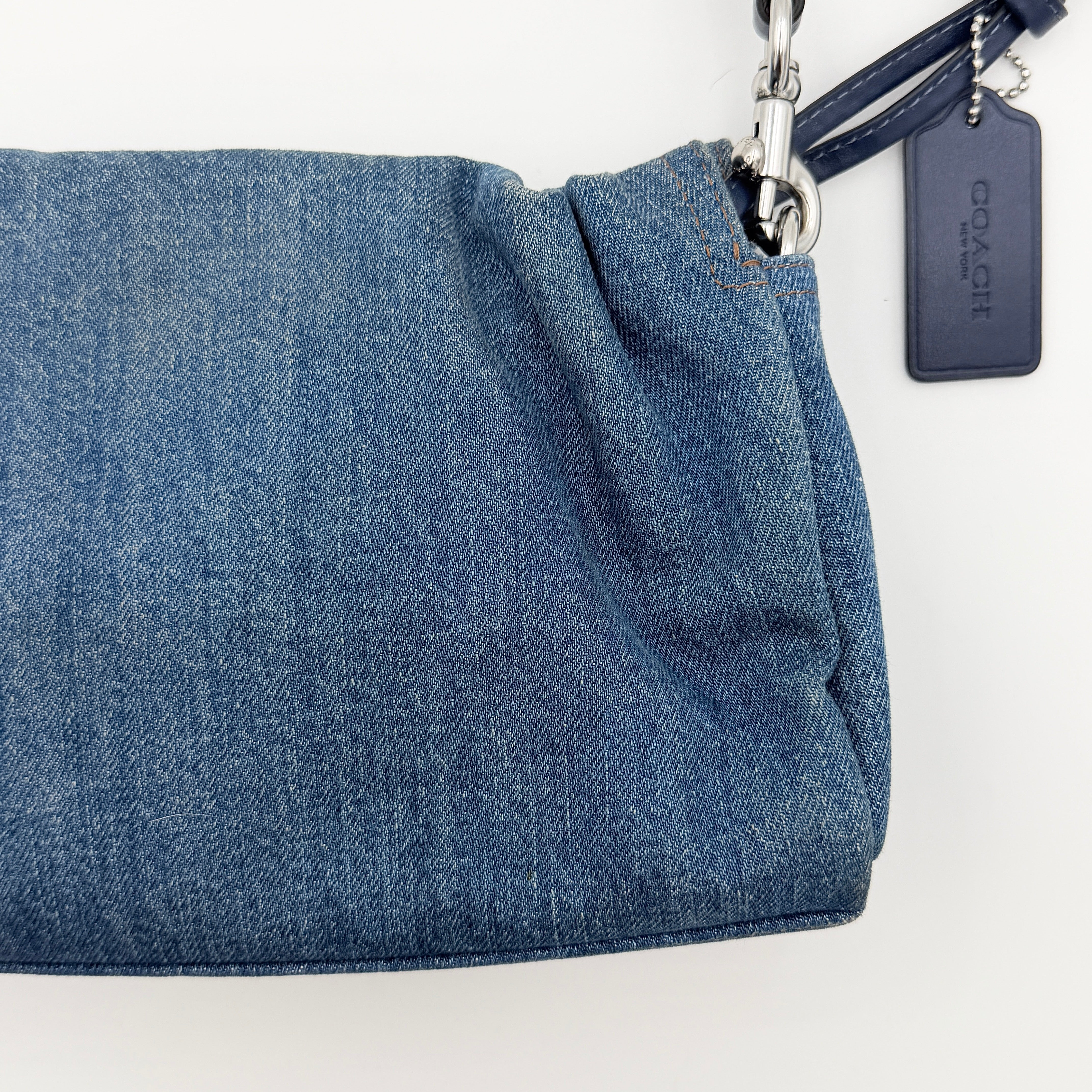 Coach Faye Shoulder Bag in blue denim with navy leather strap and detachable crossbody, styled simply against a white background.