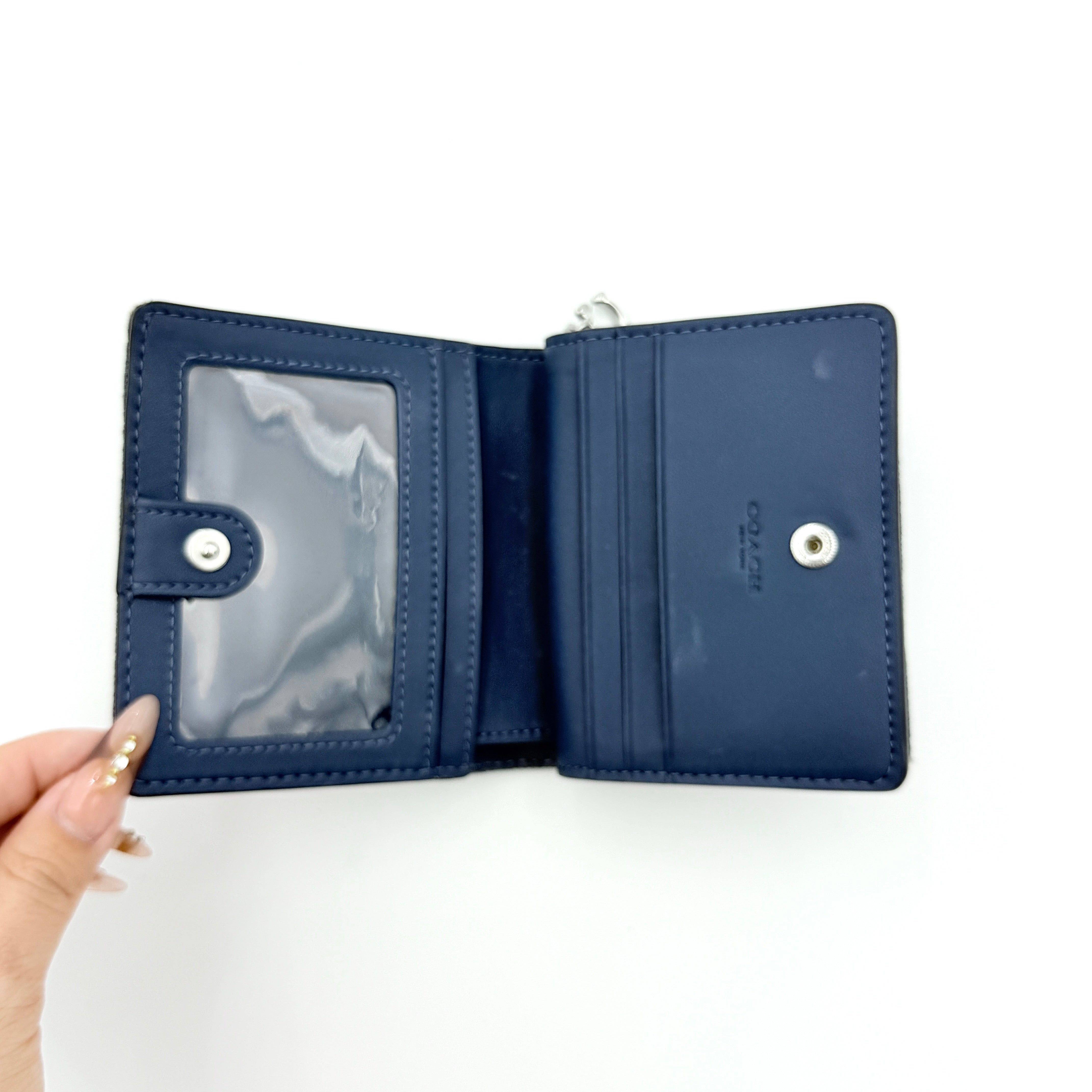 Coach Signature Snap Wallet in blue denim with silver-tone logo, shown closed from the front.