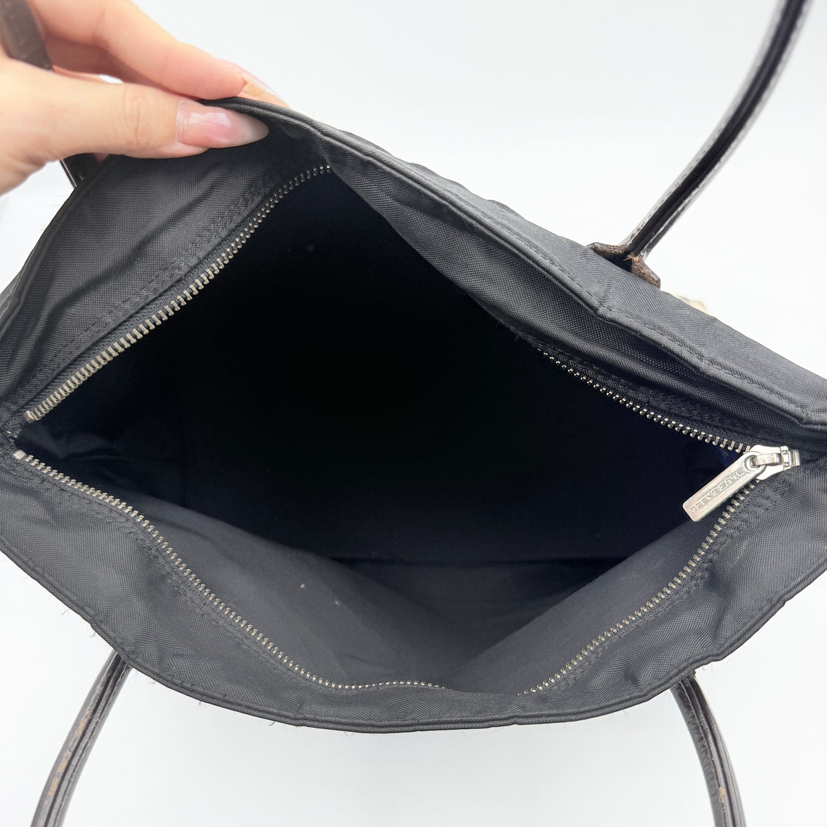 Burberry Blue Label black nylon tote bag with leather handles and nova check trim at the base.