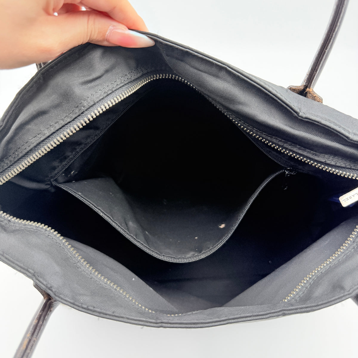 Burberry Blue Label black nylon tote bag with leather handles and nova check trim at the base.