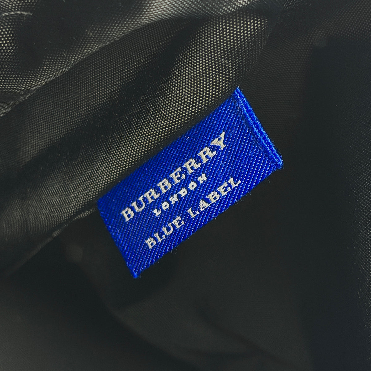 Burberry Blue Label black nylon tote bag with leather handles and nova check trim at the base.