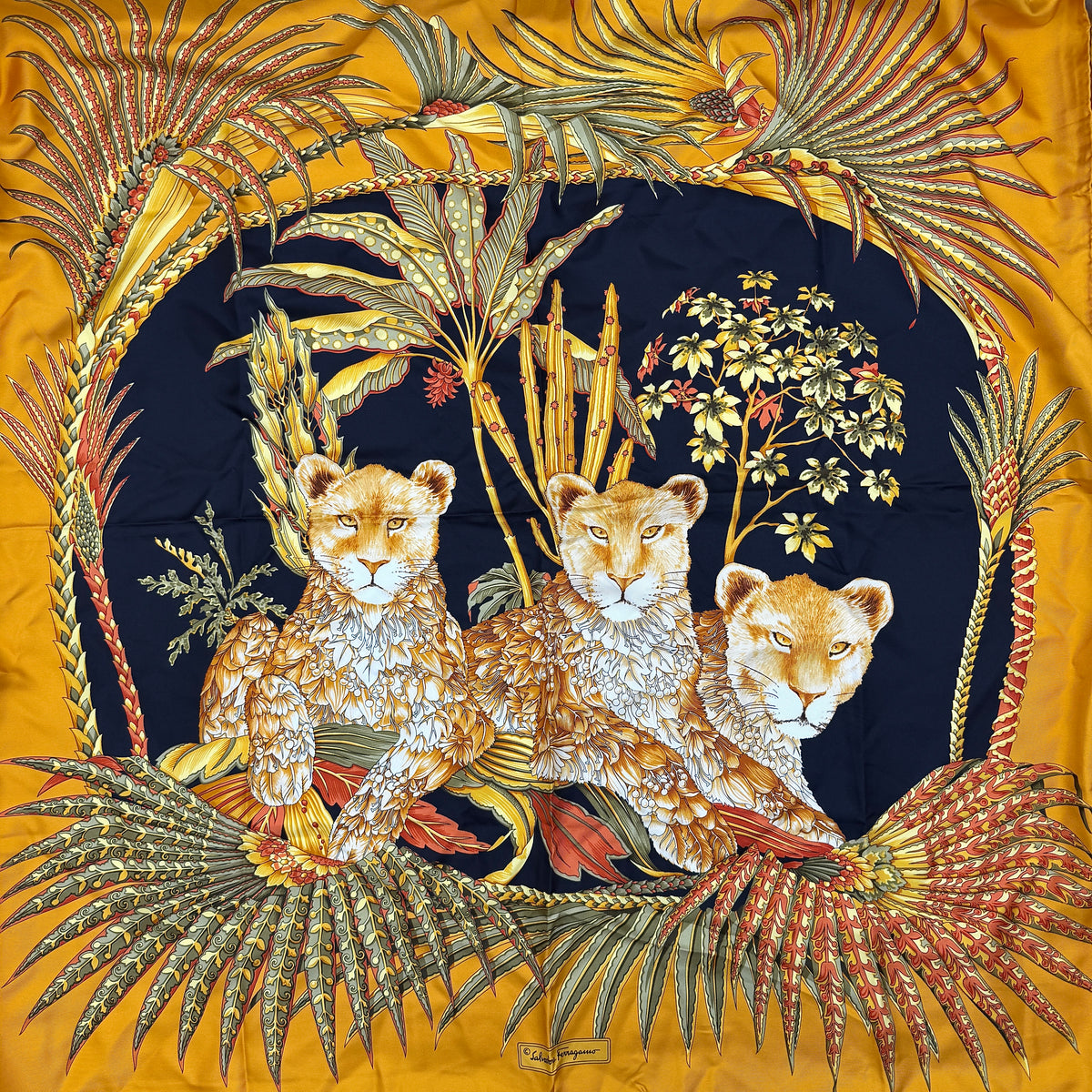 Salvatore Ferragamo silk scarf in gold and black with detailed lion and jungle botanical print.