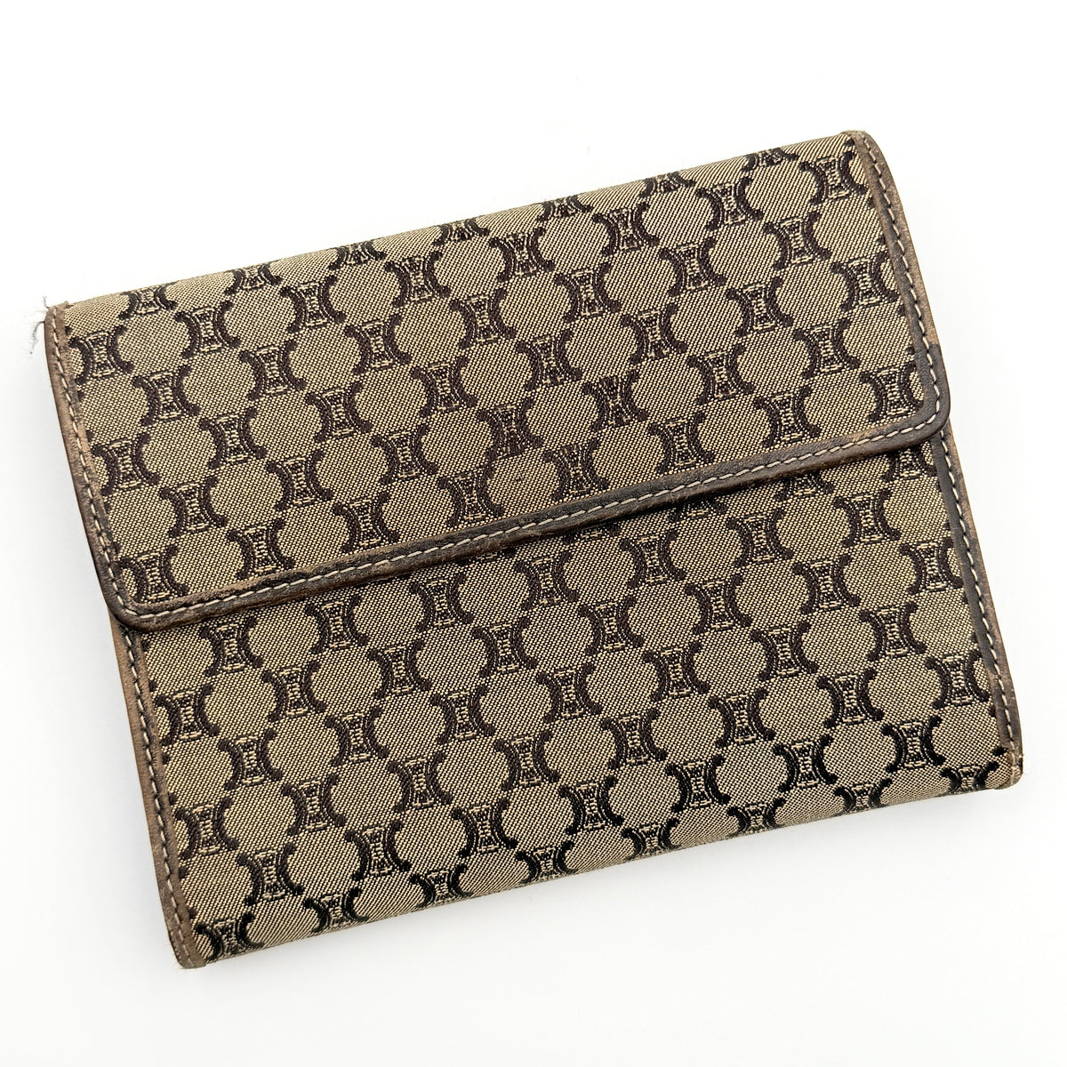 Celine Macadam Monogram Trifold Wallet in brown coated canvas with all-over motif, photographed closed on a white background
