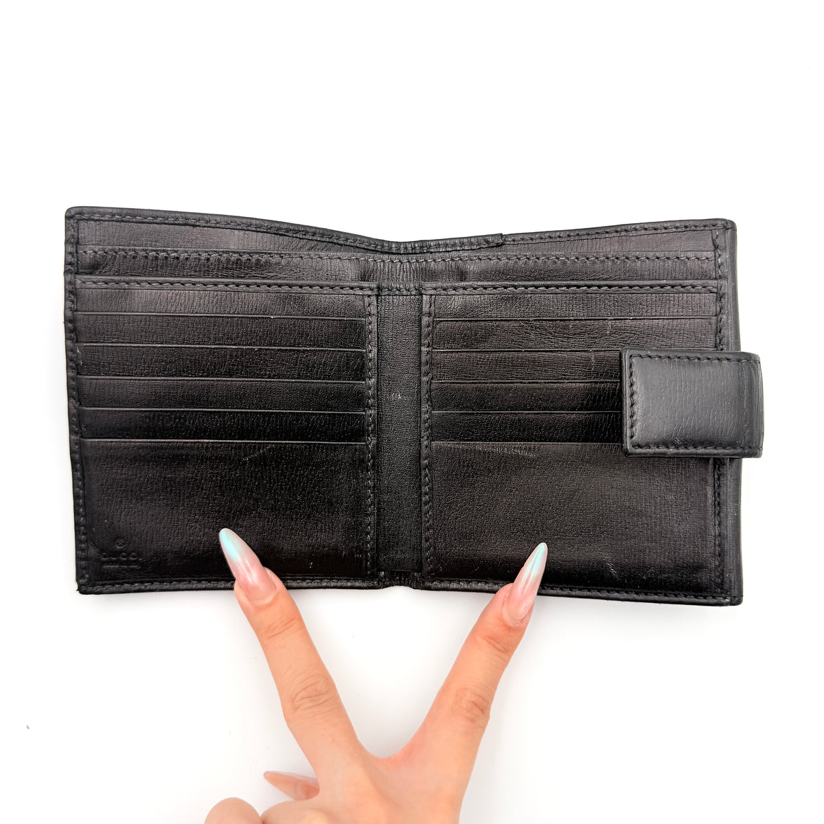 Gucci Interlocking G Heart Bifold Wallet in black leather with iconic silver-tone heart logo on the front flap.