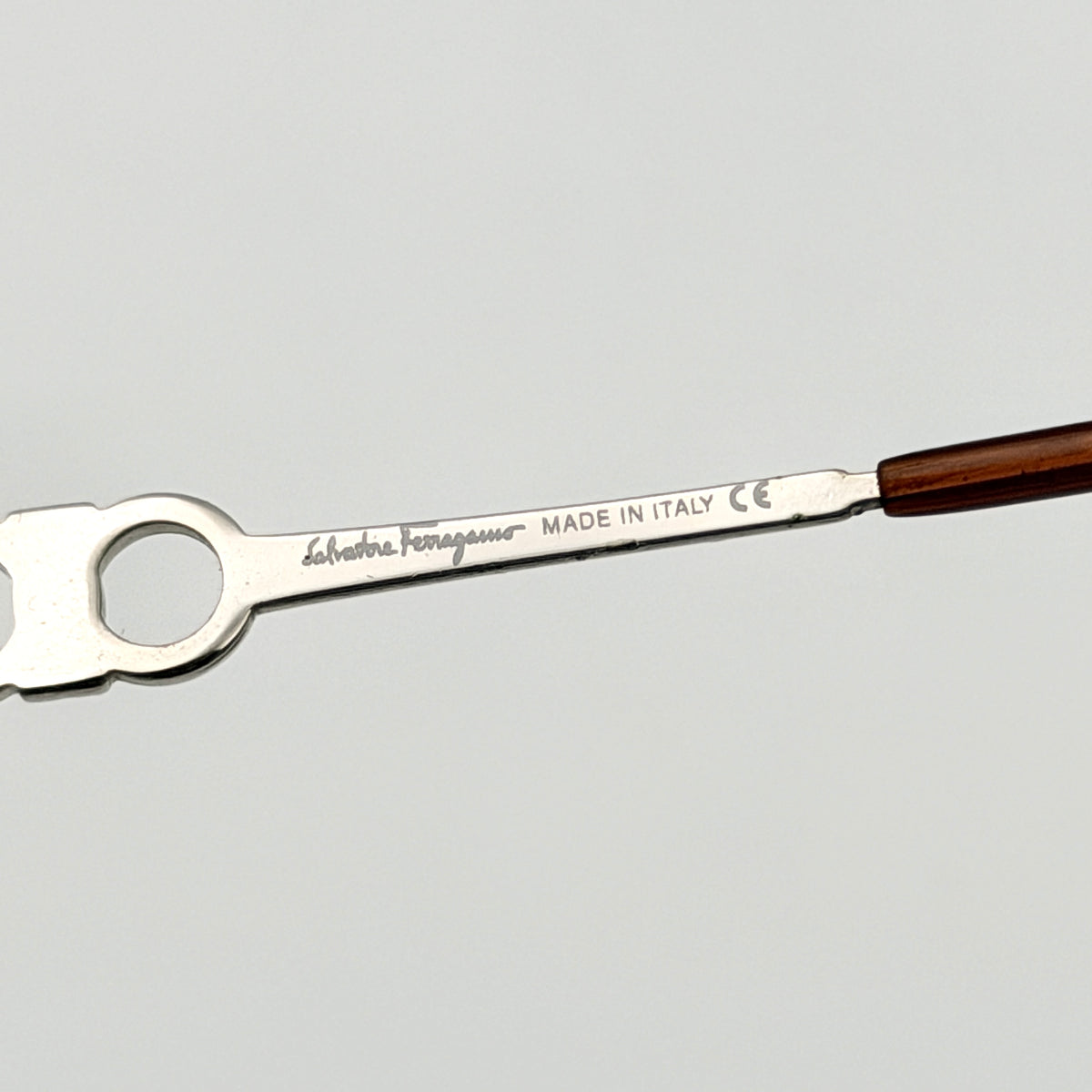 Salvatore Ferragamo rimless sunglasses with gradient brown lenses and sculptural Gancini metal arms on a white background.