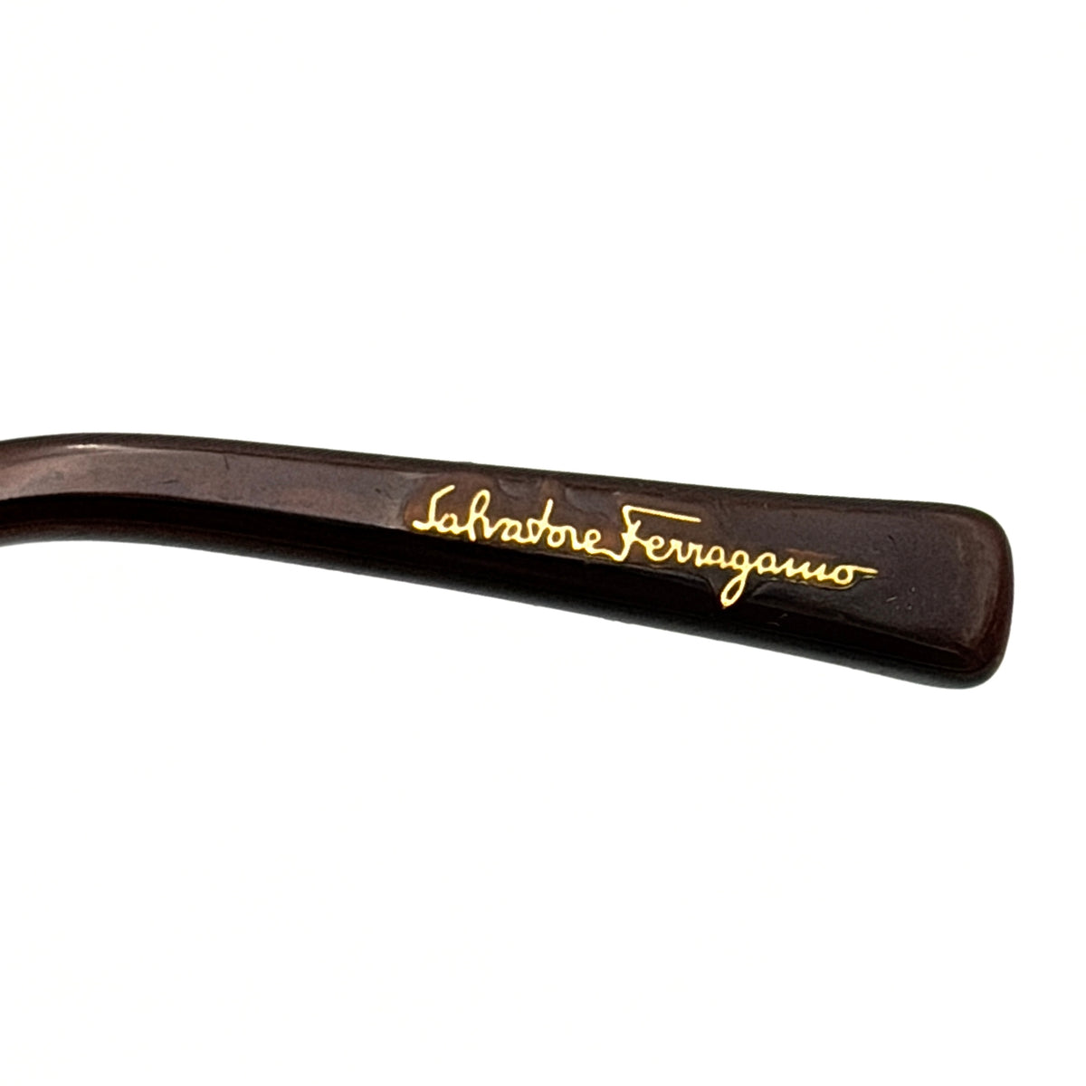 Salvatore Ferragamo rimless sunglasses with gradient brown lenses and sculptural Gancini metal arms on a white background.