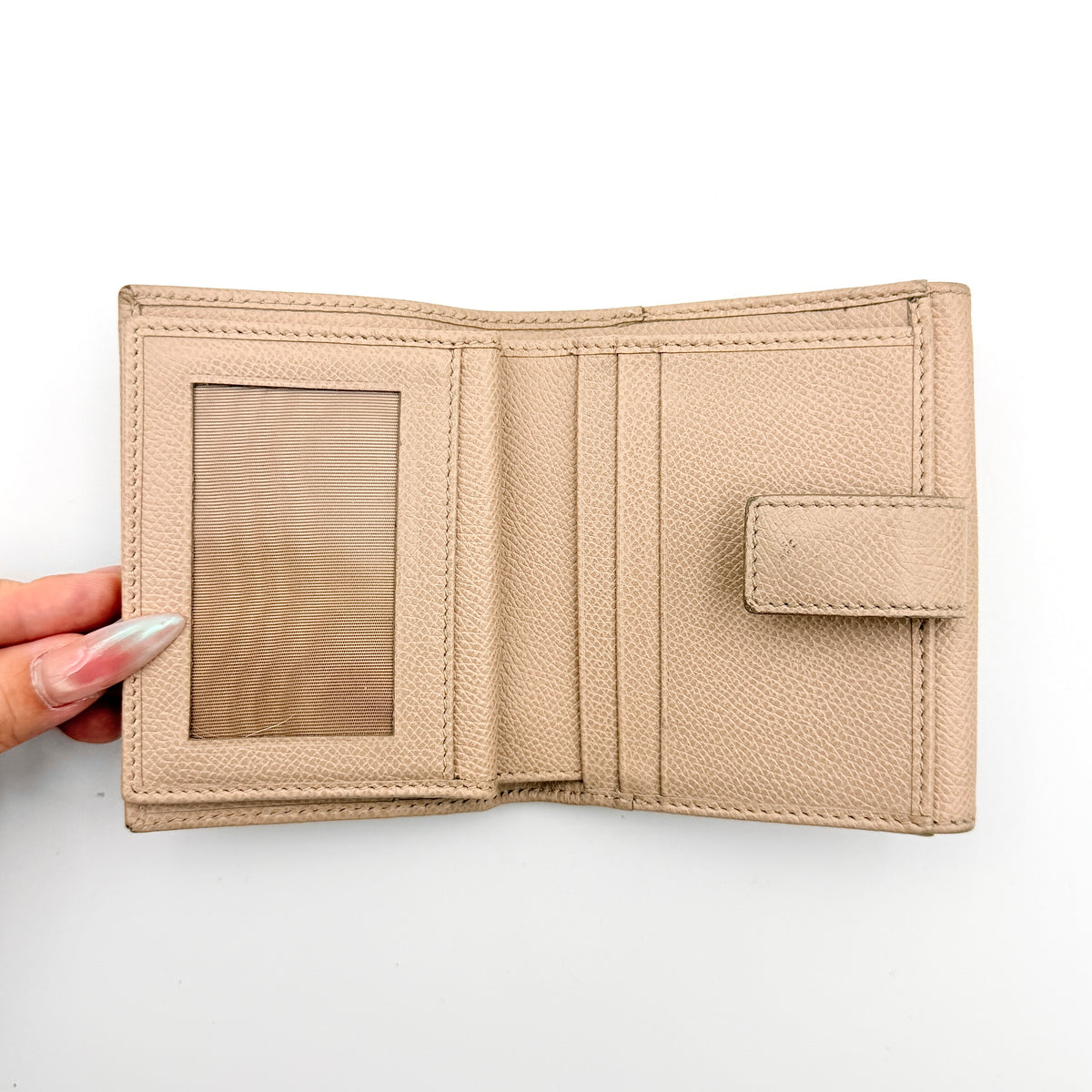 Salvatore Ferragamo beige grained leather compact bifold wallet with gold Gancini hardware, photographed on a white background.