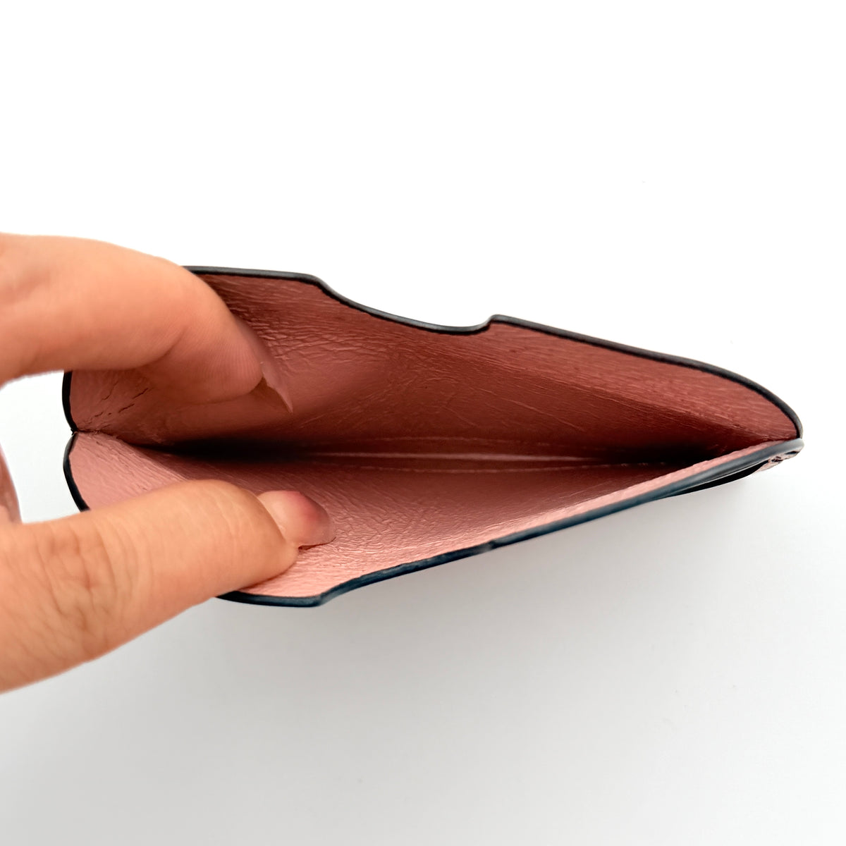 Acne Studios pink leather card holder with embossed logo and double card slots, shown against a clean white background.