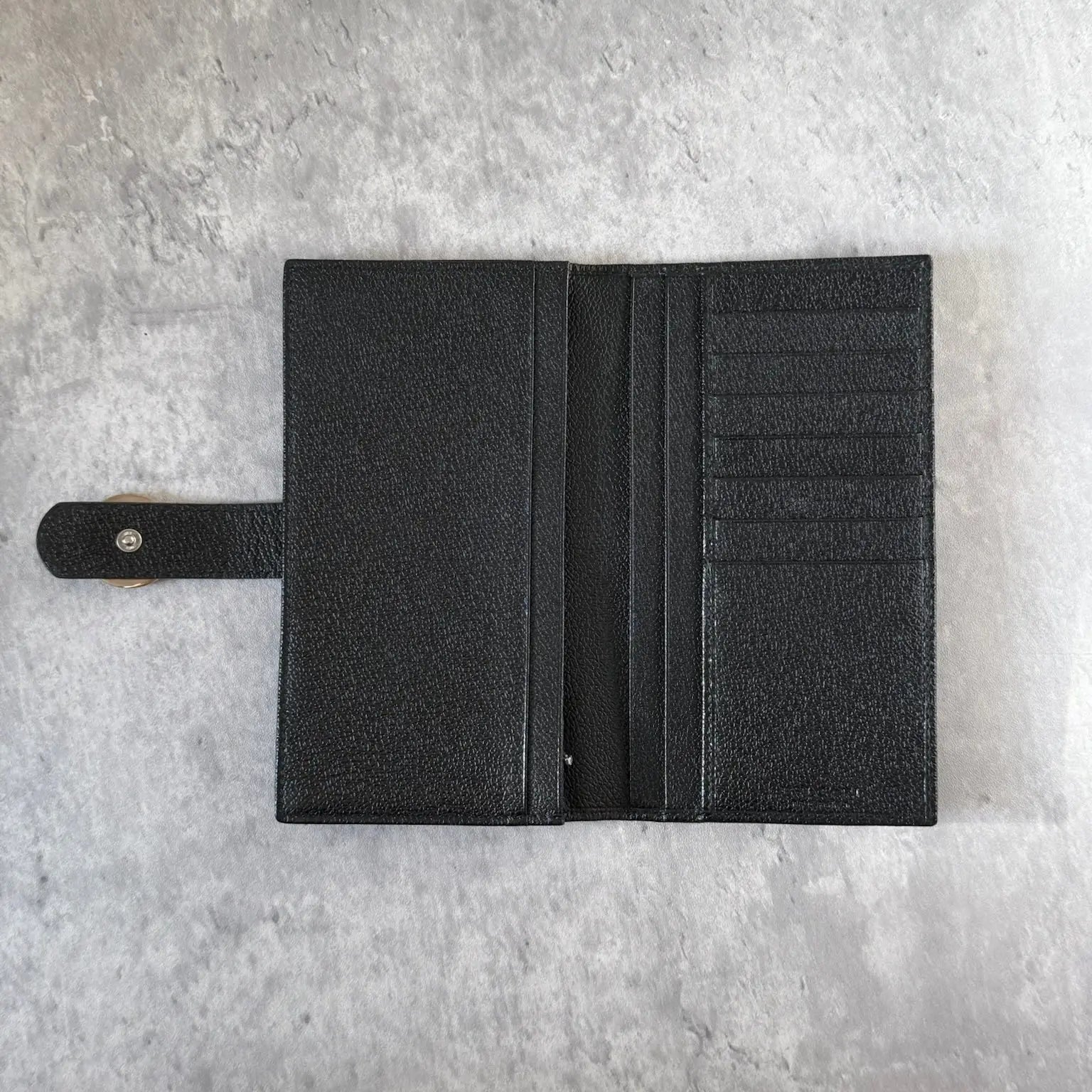 Bvlgari Black Leather Signature Ring Fold Long Wallet with a logo ring closure and red interior.