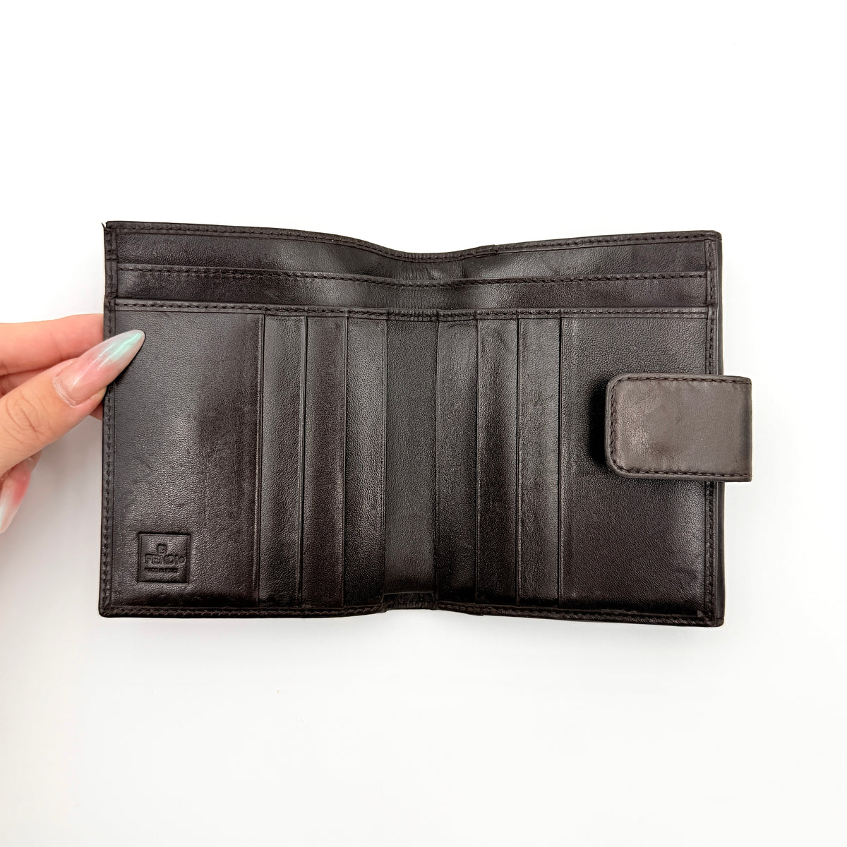 Fendi FF Zucca bifold wallet in brown and black canvas with leather trim, front snap tab detail.