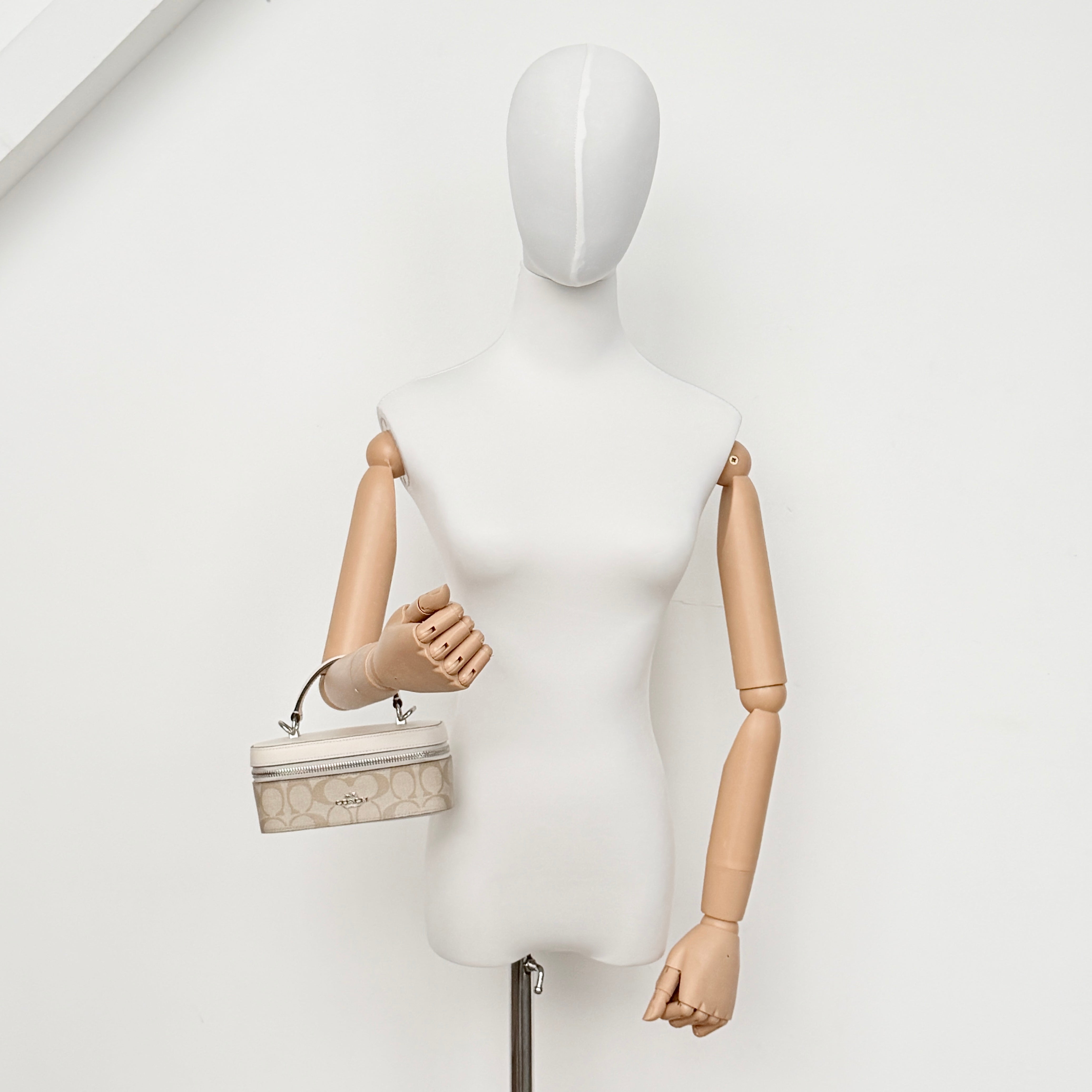 Coach 2Way Signature Train Case in beige and white canvas with a leather top handle and detachable strap, shown with silver zip hardware.