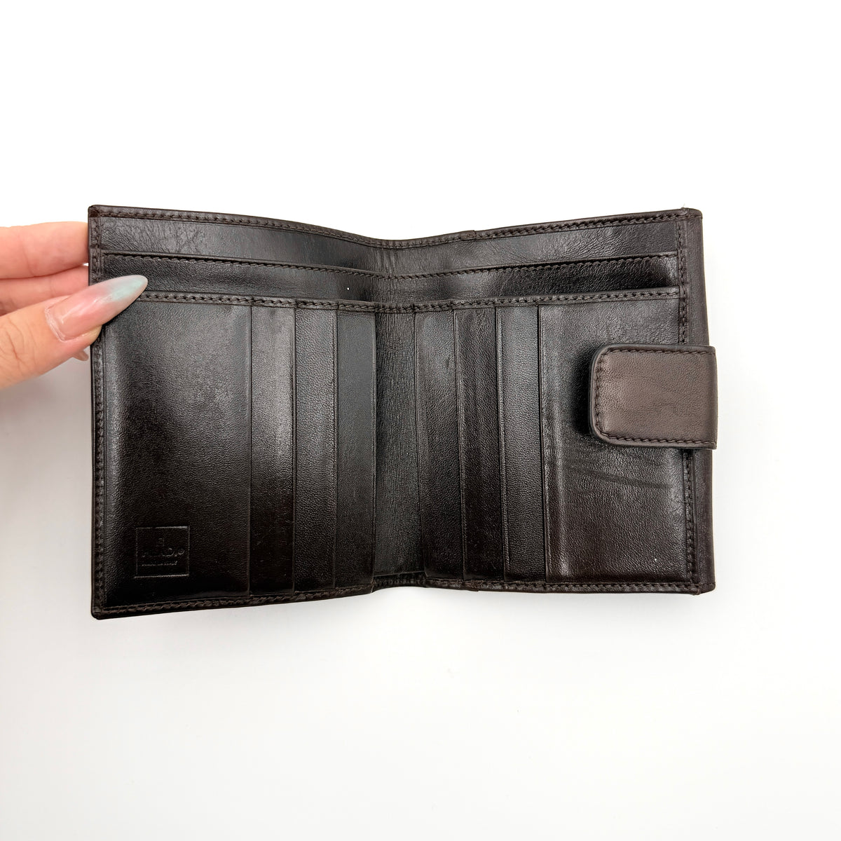 Fendi FF Zucca Monogram bifold wallet in brown and black leather with snap closure, photographed on a white background.