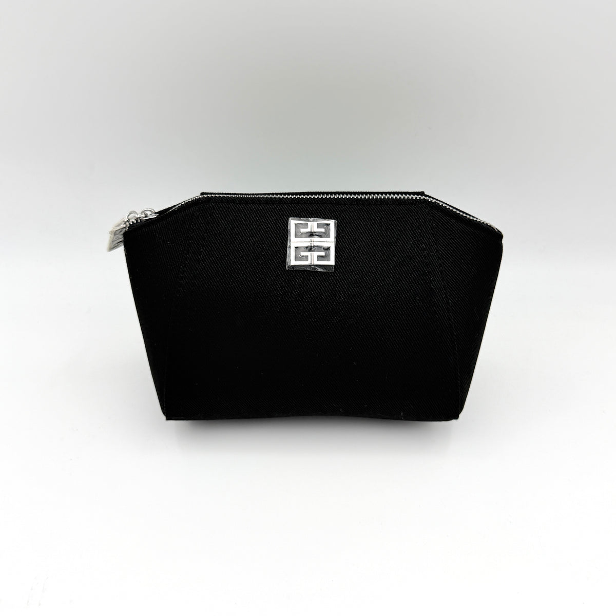 Givenchy black cosmetic pouch with silver-tone logo plaque and zip, photographed against a clean white background.