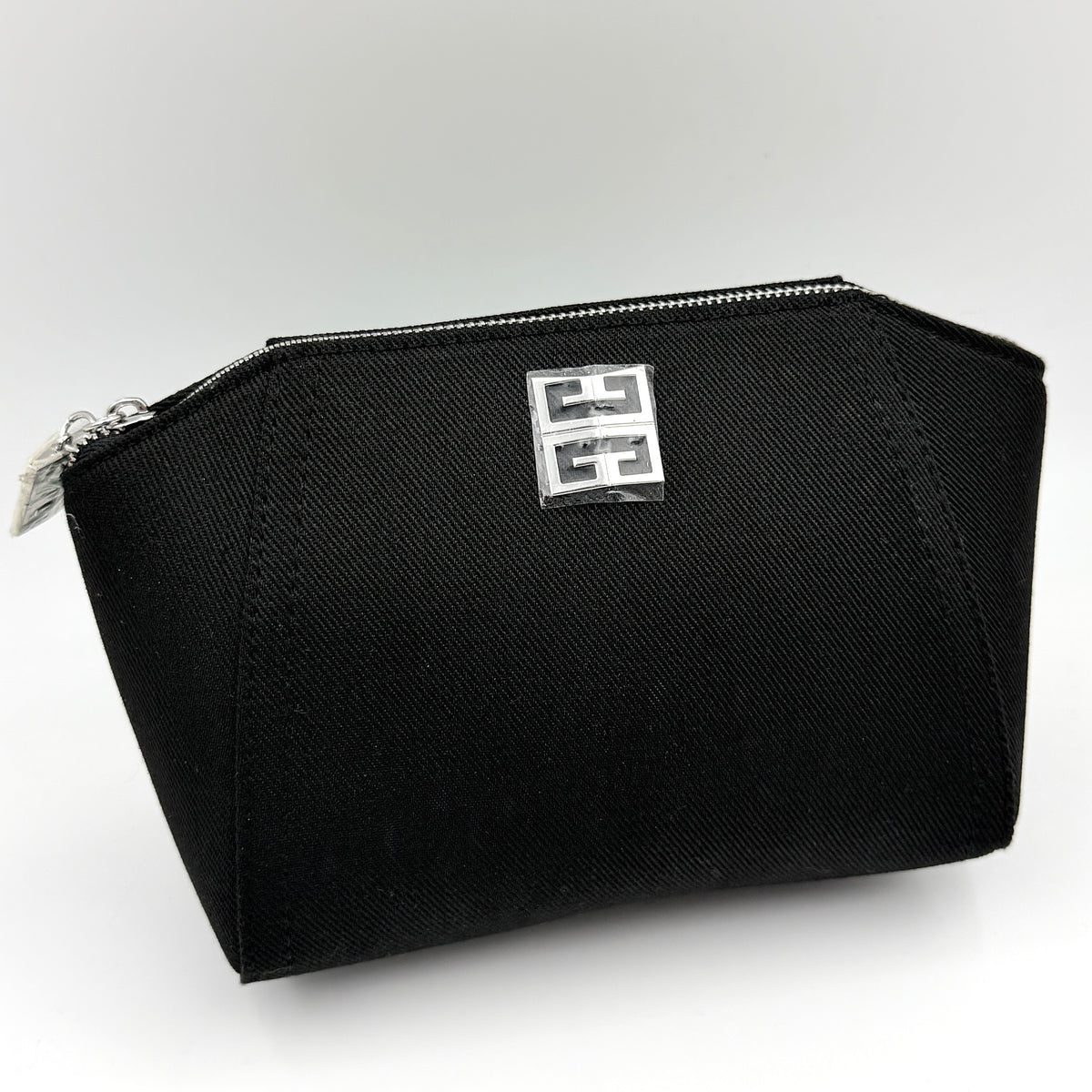 Givenchy black cosmetic pouch with silver-tone logo plaque and zip, photographed against a clean white background.