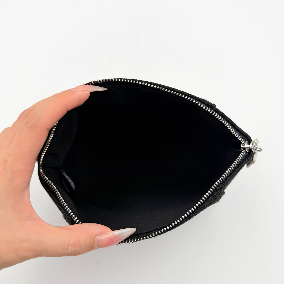 Givenchy black cosmetic pouch with silver-tone logo plaque and zip, photographed against a clean white background.