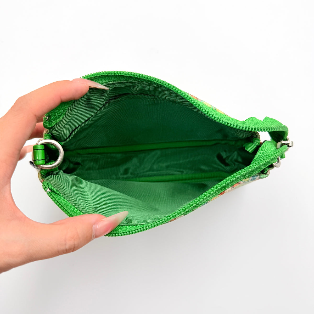 Burberry Blue Label geometric pouch in multicolor canvas with green trim and zip closure, photographed against a clean white background.