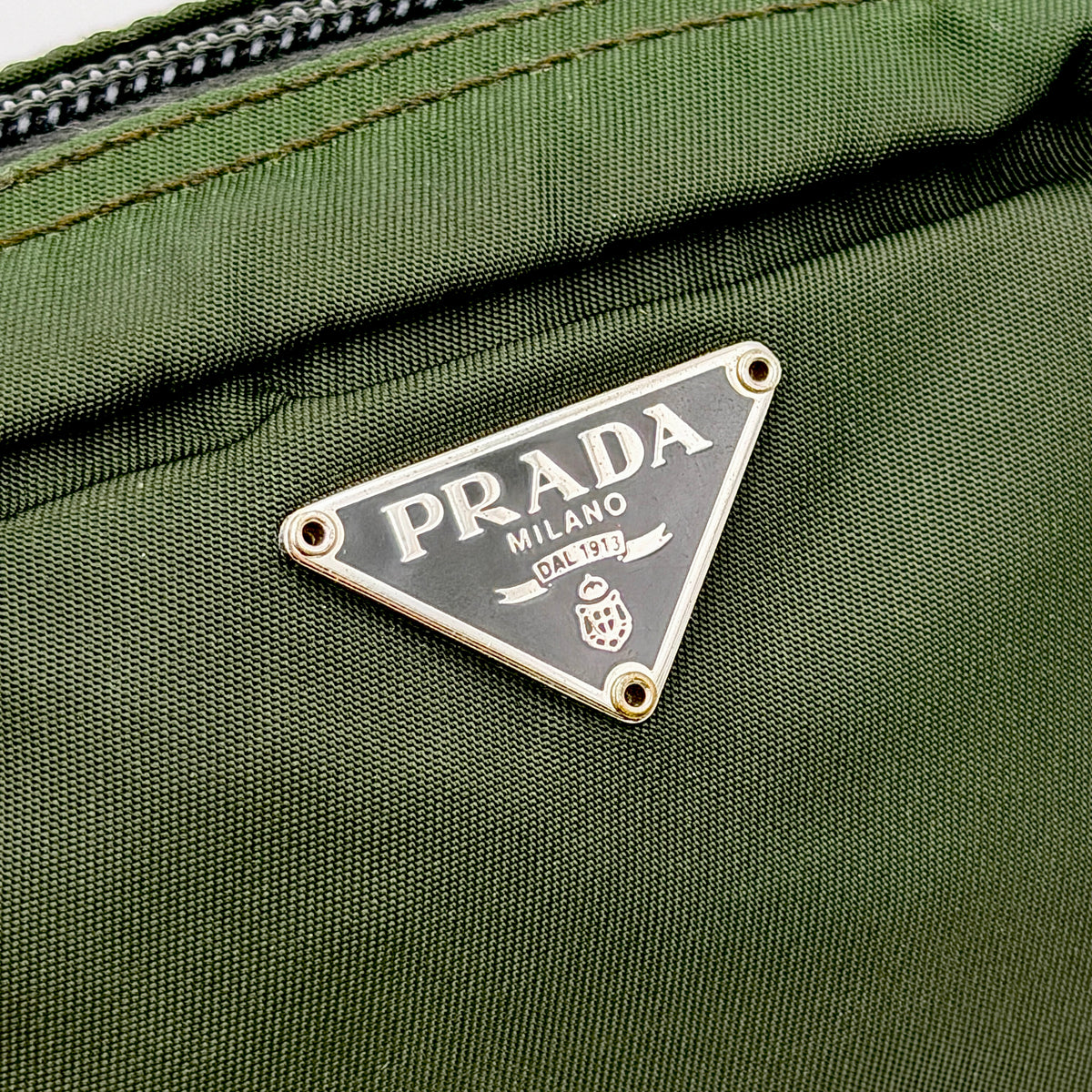 Prada Nylon Utility Pouch in dark green with silver triangle logo and zip closure.
