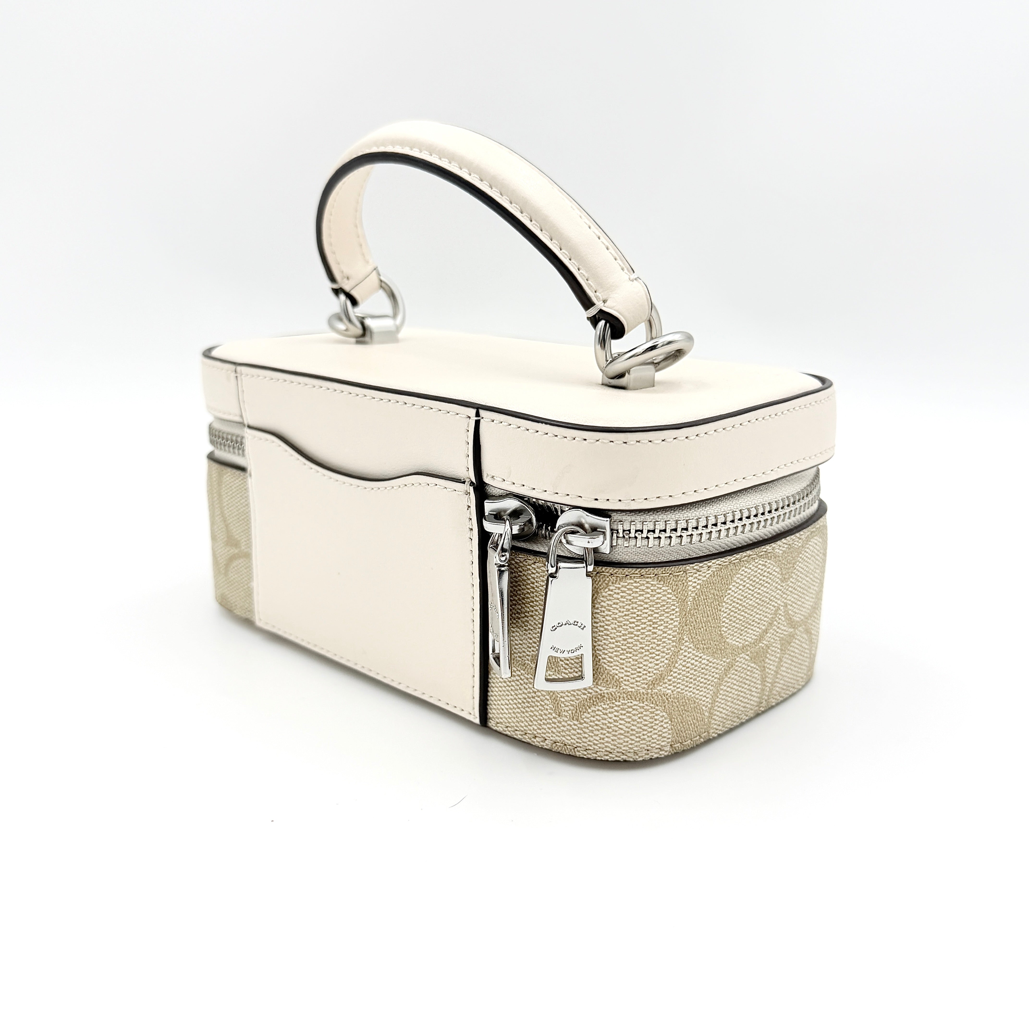 Coach 2Way Signature Train Case in beige and white canvas with a leather top handle and detachable strap, shown with silver zip hardware.