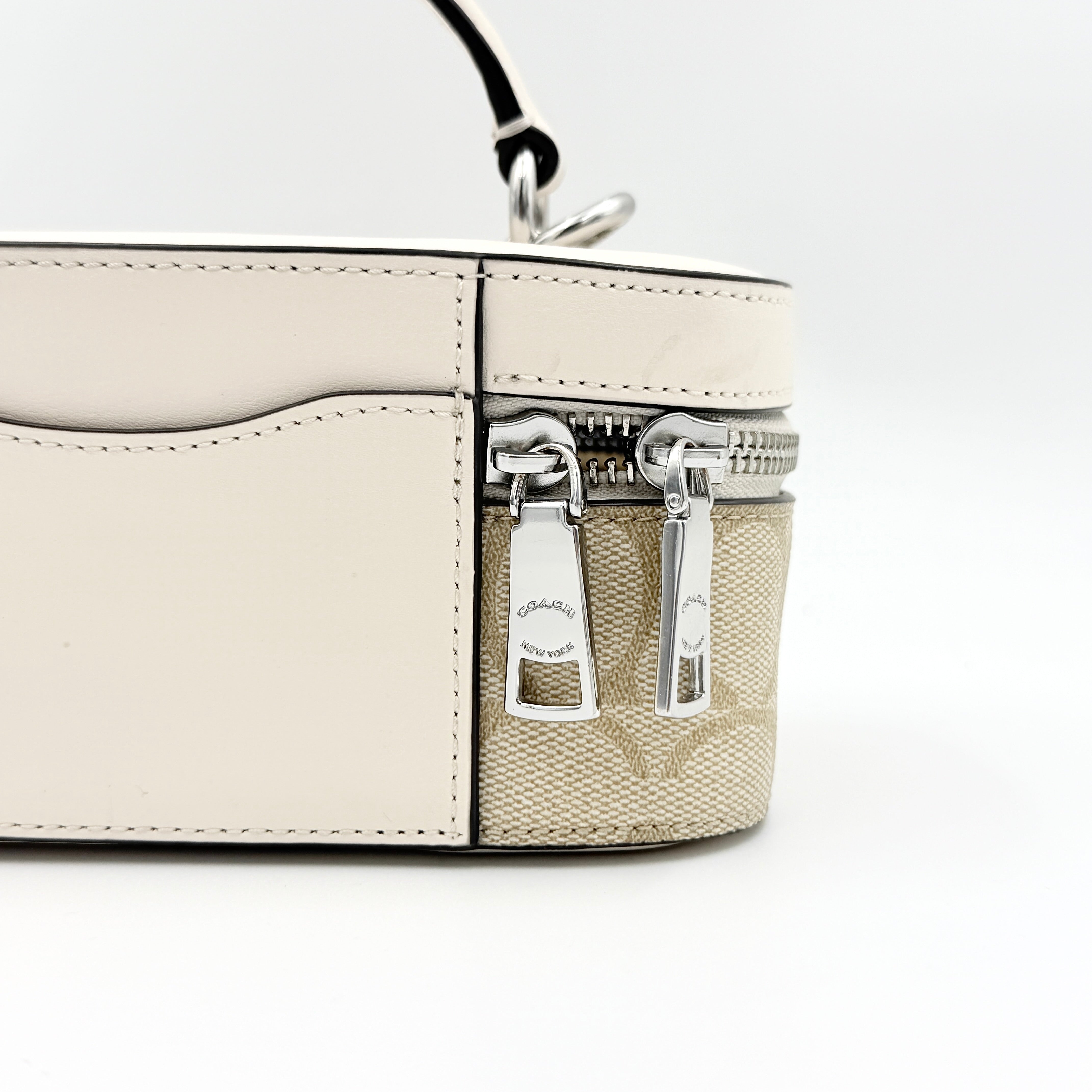 Coach 2Way Signature Train Case in beige and white canvas with a leather top handle and detachable strap, shown with silver zip hardware.
