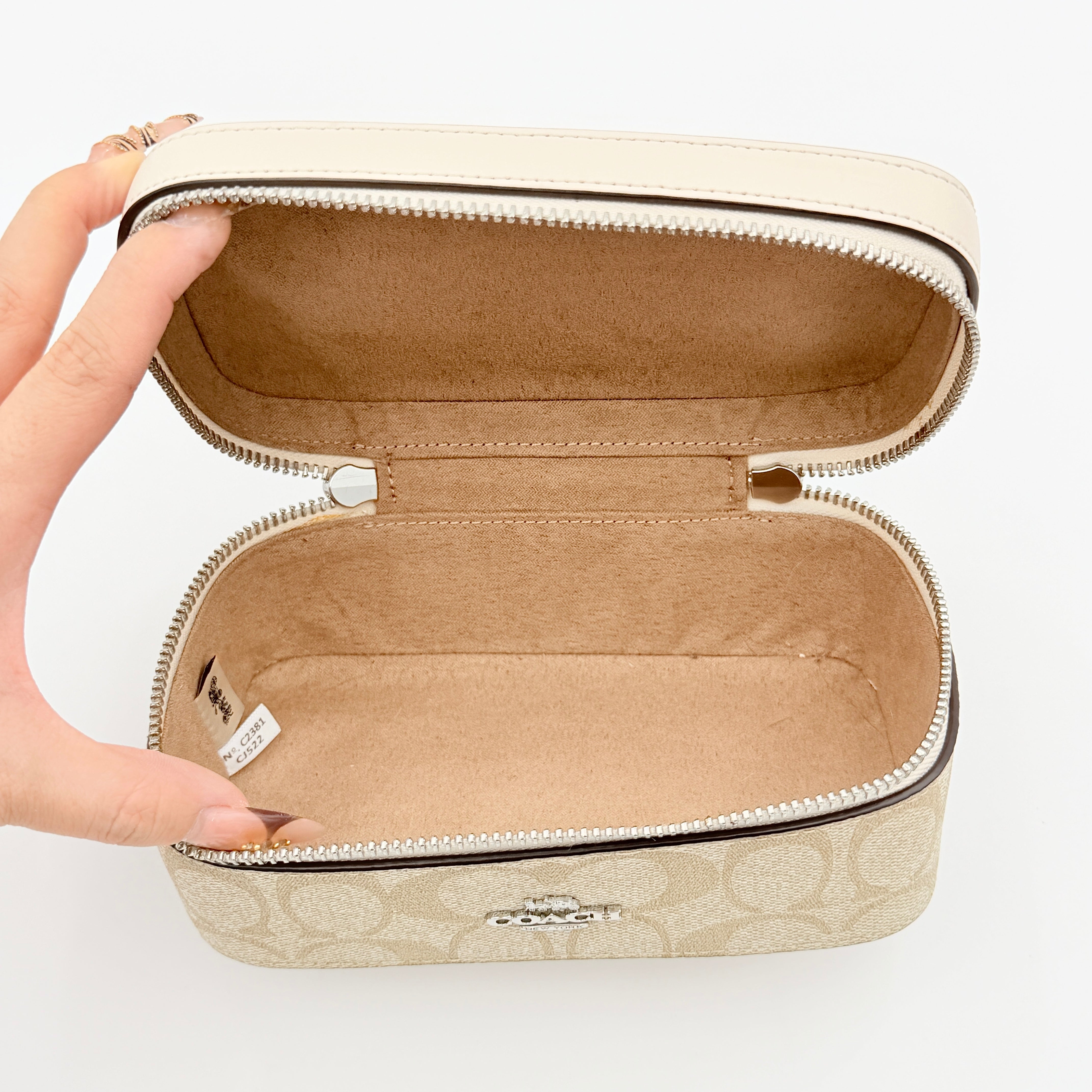 Coach 2Way Signature Train Case in beige and white canvas with a leather top handle and detachable strap, shown with silver zip hardware.