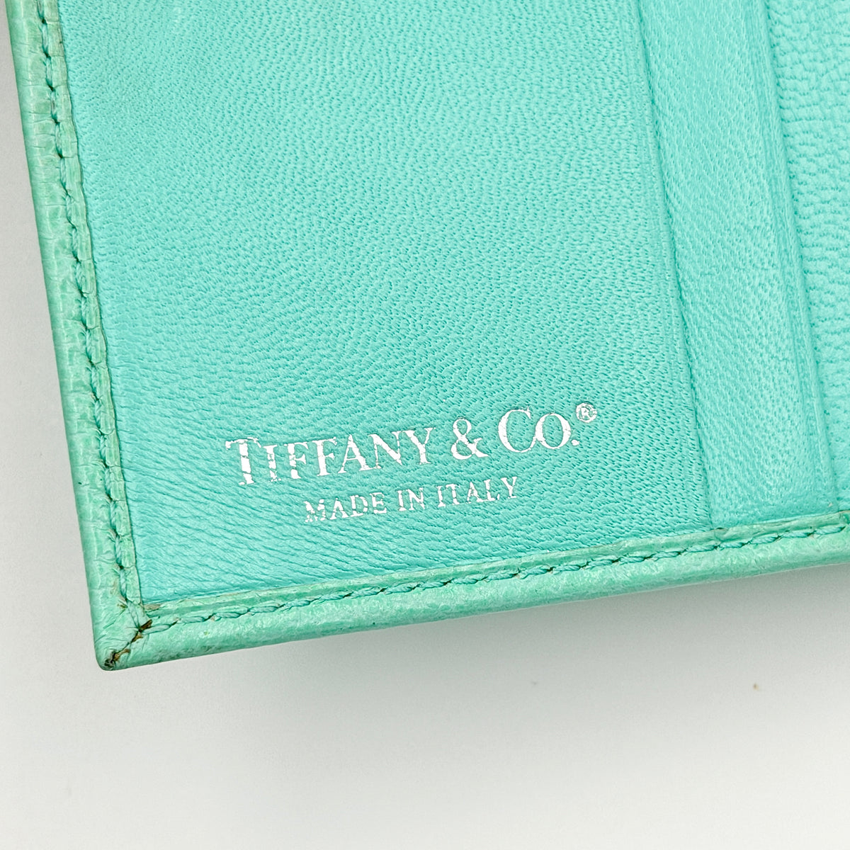 Tiffany & Co. bifold compact wallet in Tiffany Blue leather with silver-tone clasp, photographed on a clean white background.