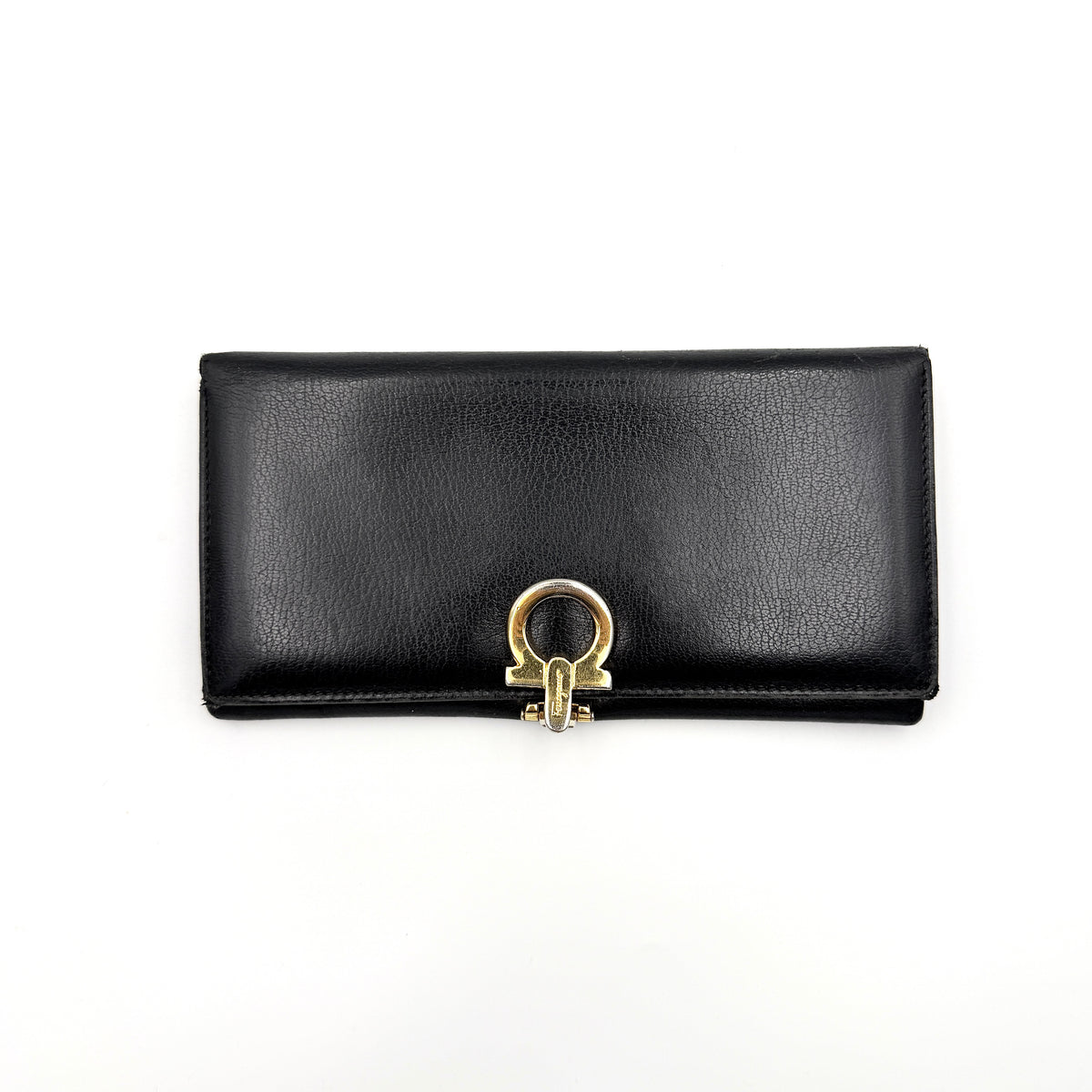 Salvatore Ferragamo Gancini Continental Wallet in black leather with gold-tone Gancini clasp, photographed closed on a white background.