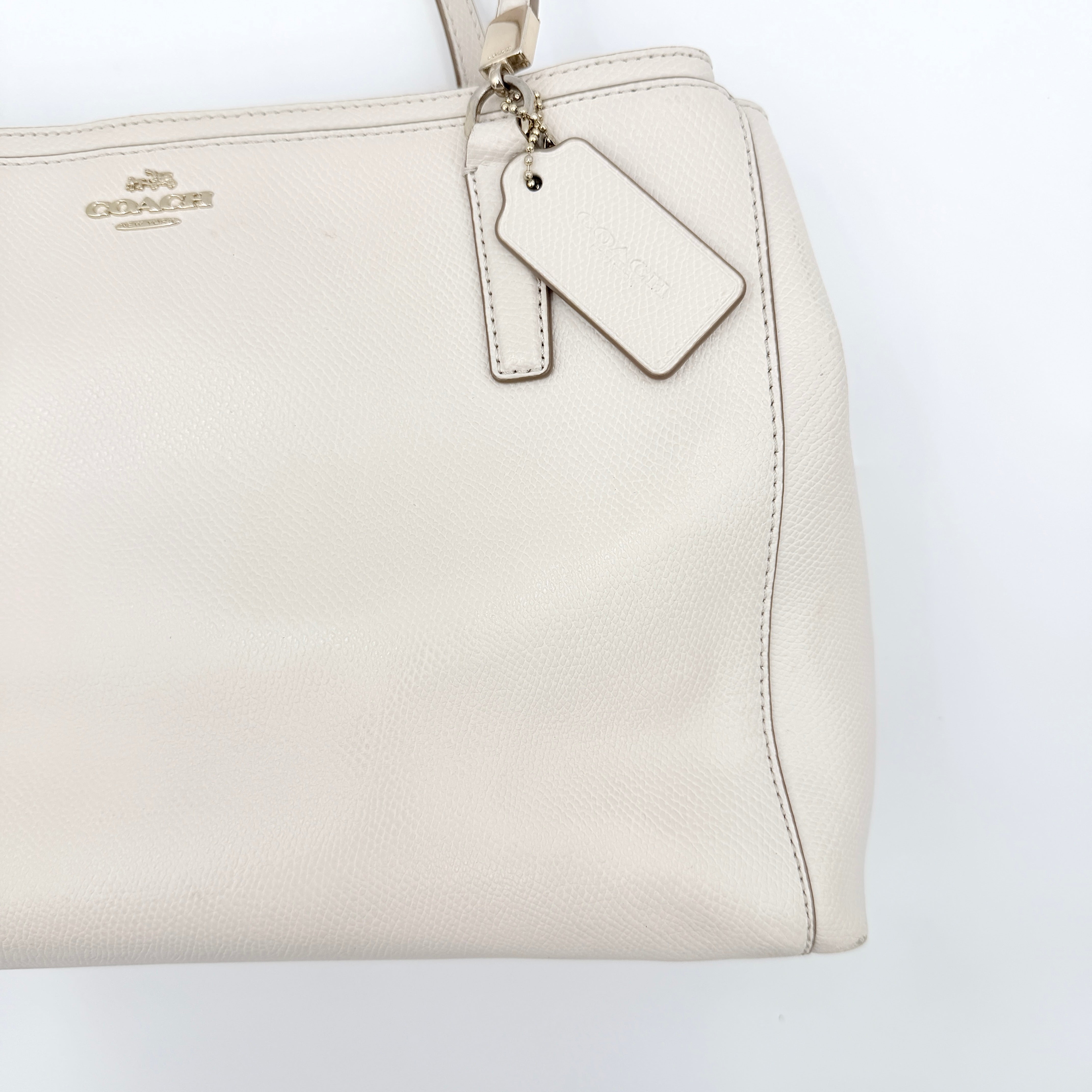 Coach Parker 16 shoulder bag in white leather with dual top handles and gold-tone accents, displayed against a clean background.