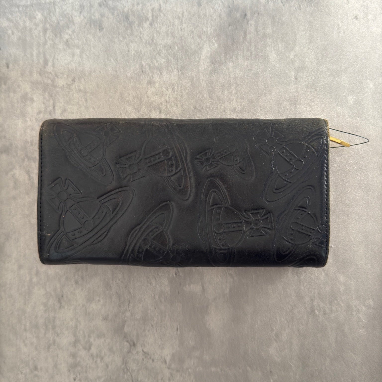 Vivienne Westwood Dancing Orb long wallet in black with iconic orb embossing, featuring a structured interior and clip closure, represents bold, punk-inspired luxury.