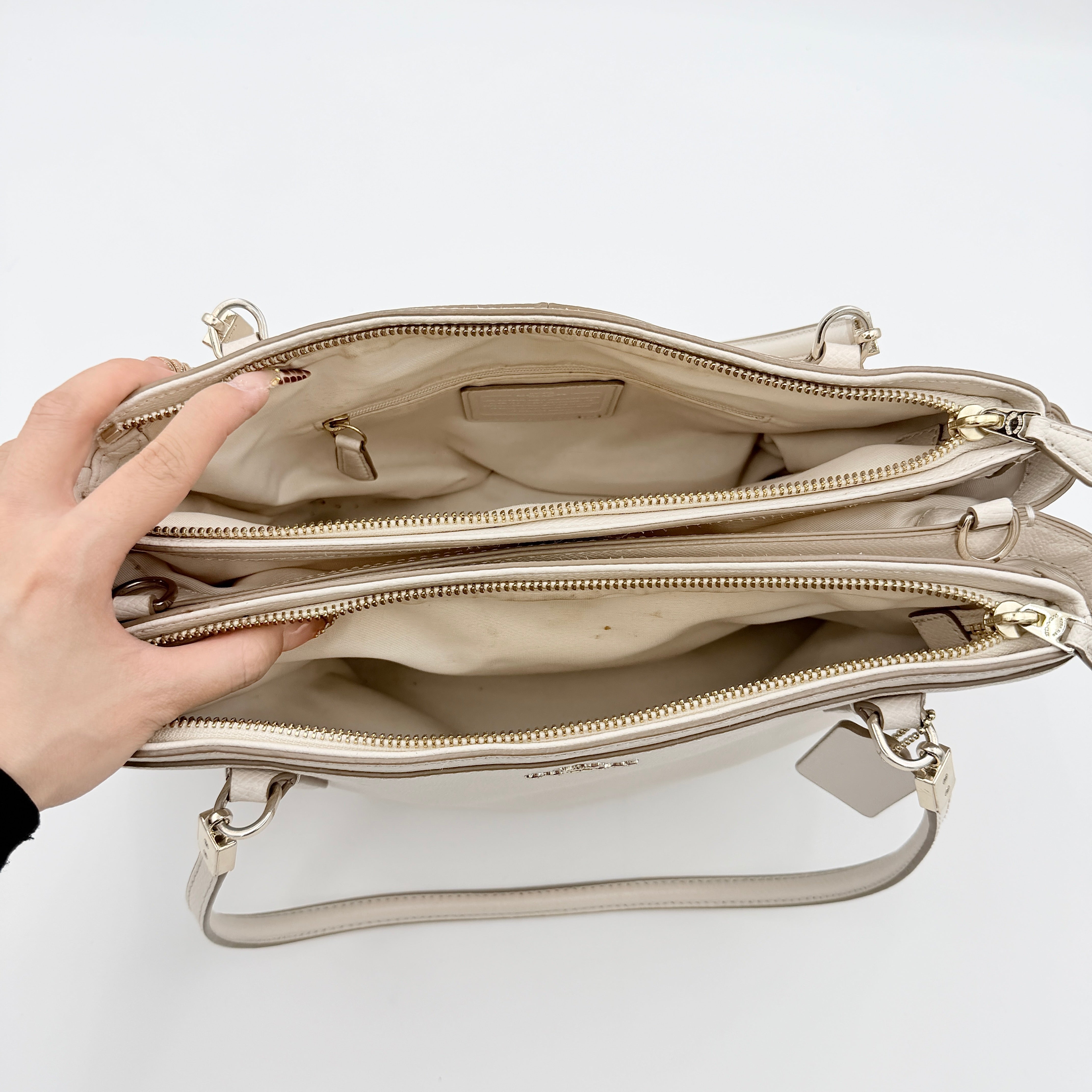 Coach Parker 16 shoulder bag in white leather with dual top handles and gold-tone accents, displayed against a clean background.