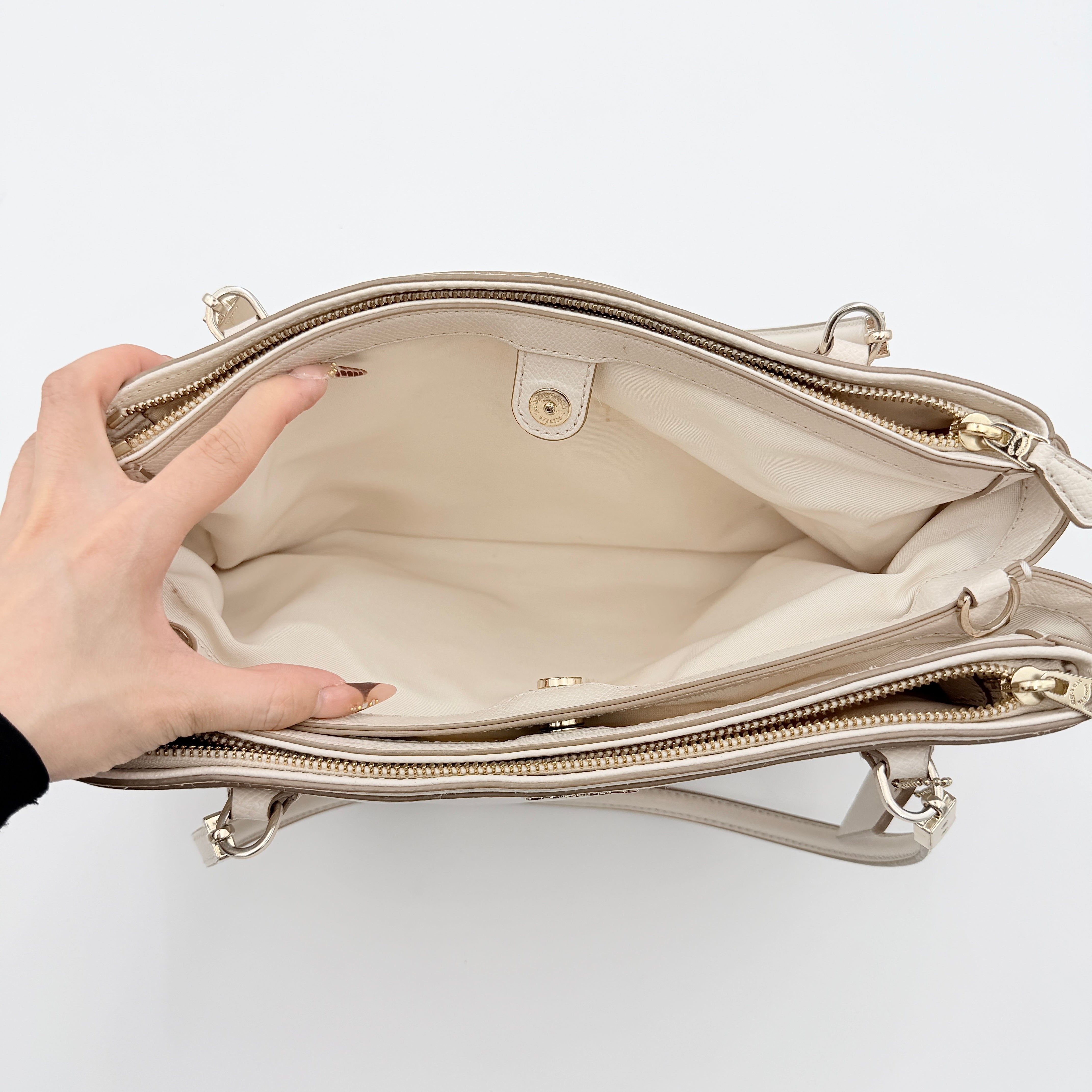 Coach Parker 16 shoulder bag in white leather with dual top handles and gold-tone accents, displayed against a clean background.