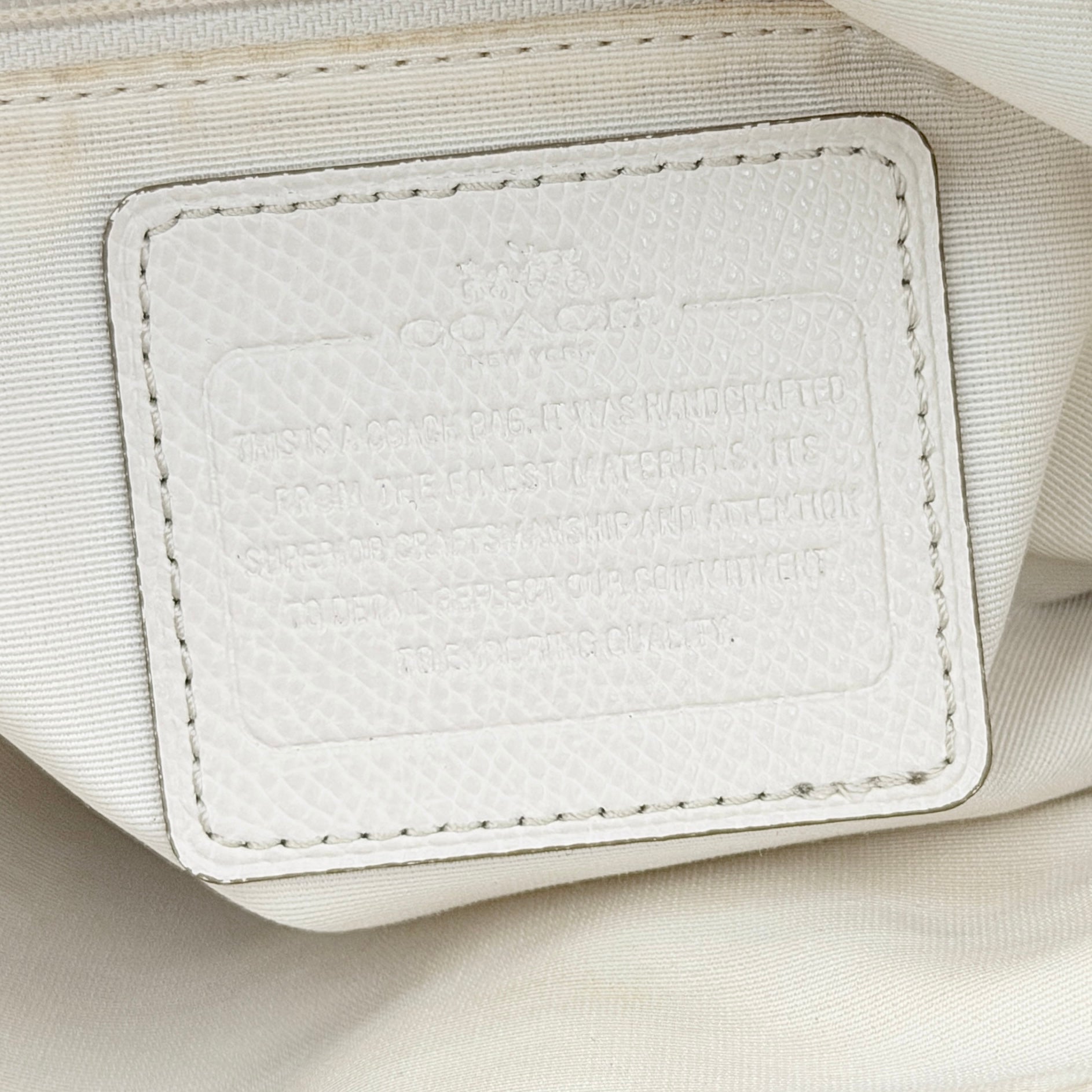 Coach Parker 16 shoulder bag in white leather with dual top handles and gold-tone accents, displayed against a clean background.