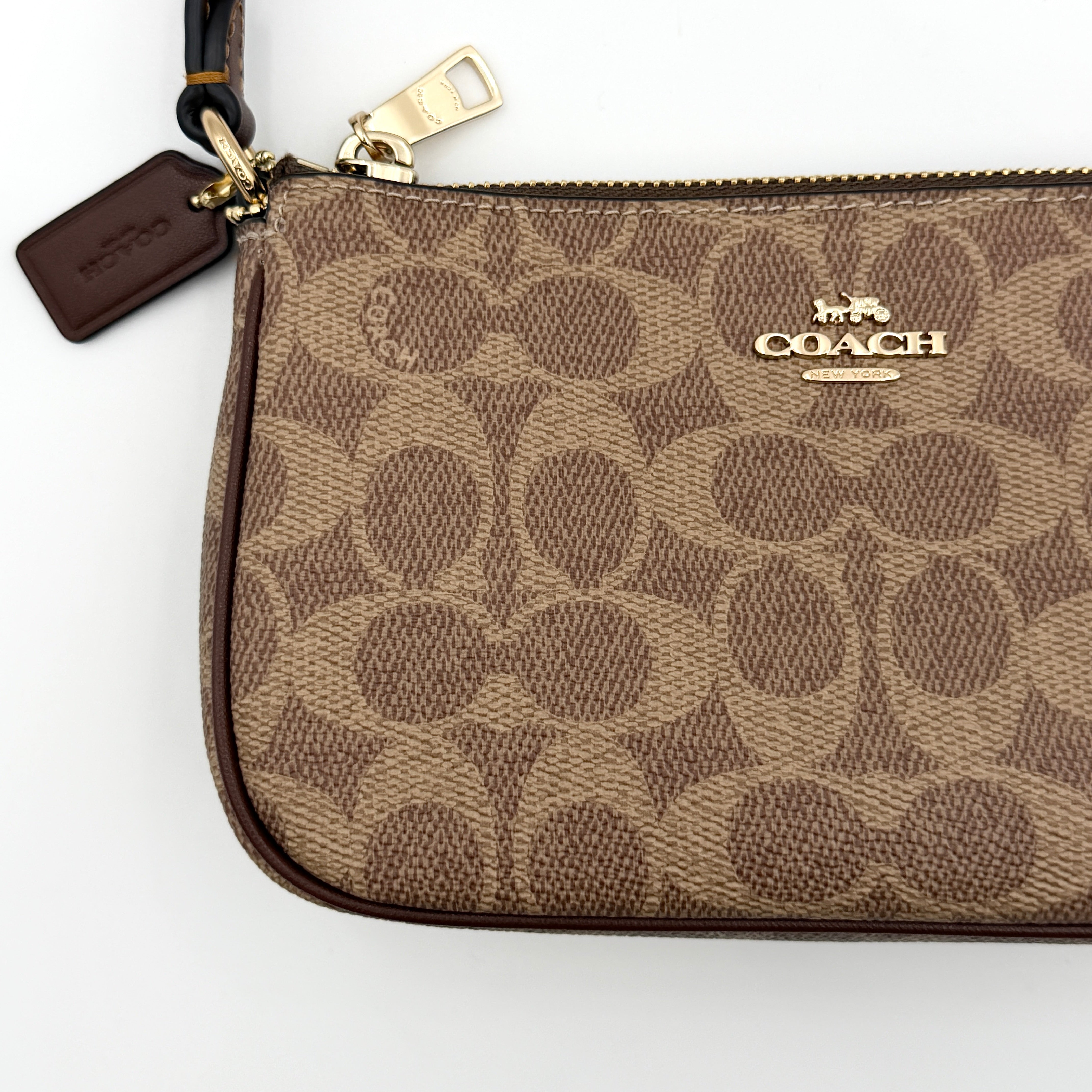 Coach Signature Nolita 19 Shoulder Bag in beige and brown canvas with gold tone hardware and detachable leather strap.