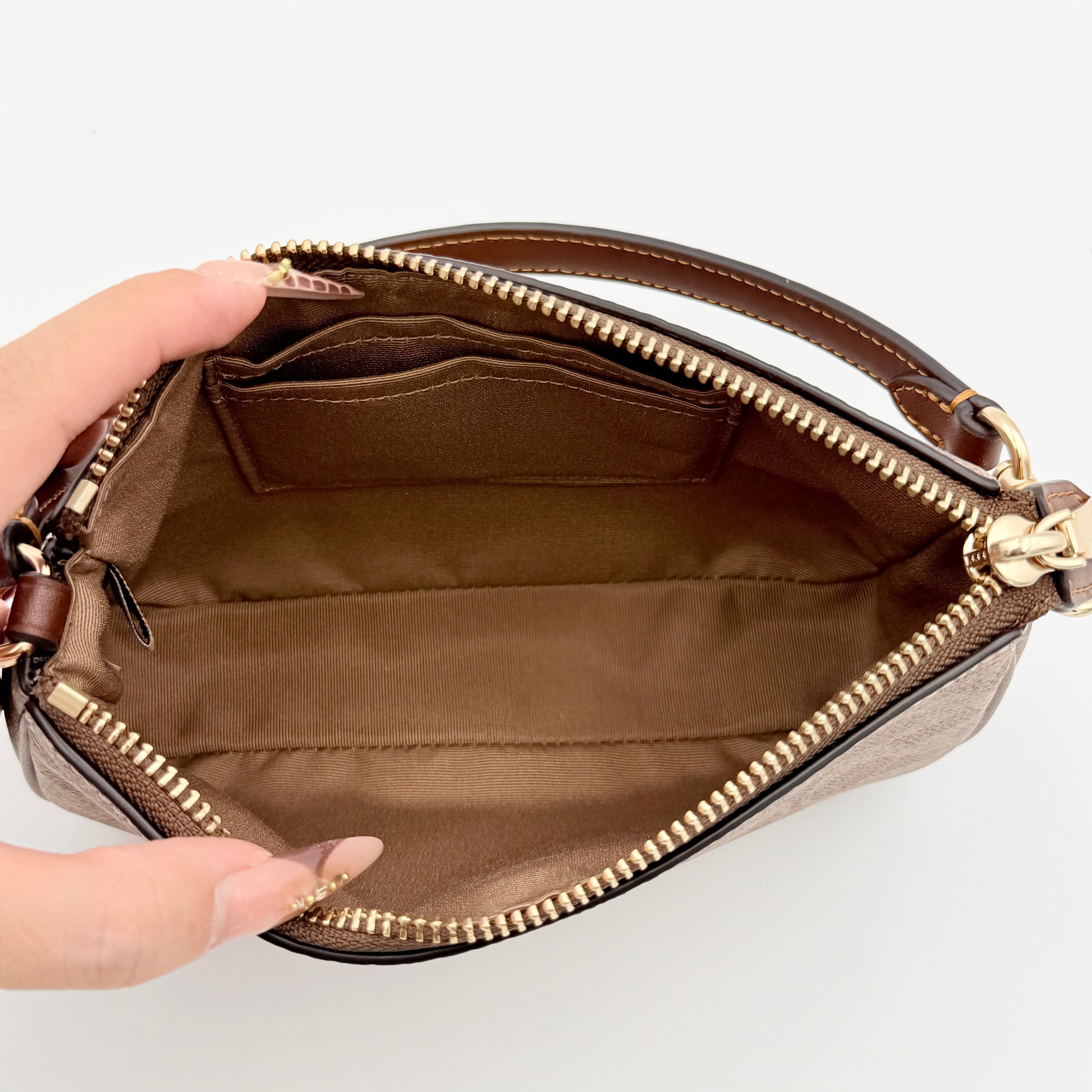 Coach Signature Nolita 19 Shoulder Bag in beige and brown canvas with gold tone hardware and detachable leather strap.