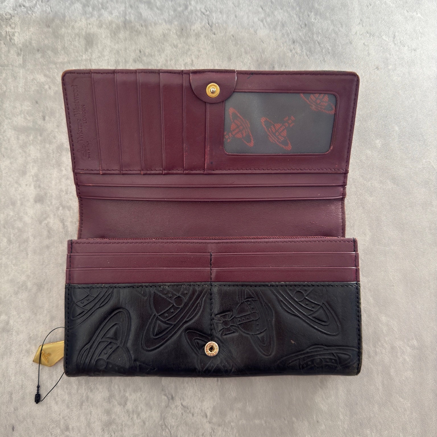 Vivienne Westwood Dancing Orb long wallet in black with iconic orb embossing, featuring a structured interior and clip closure, represents bold, punk-inspired luxury.