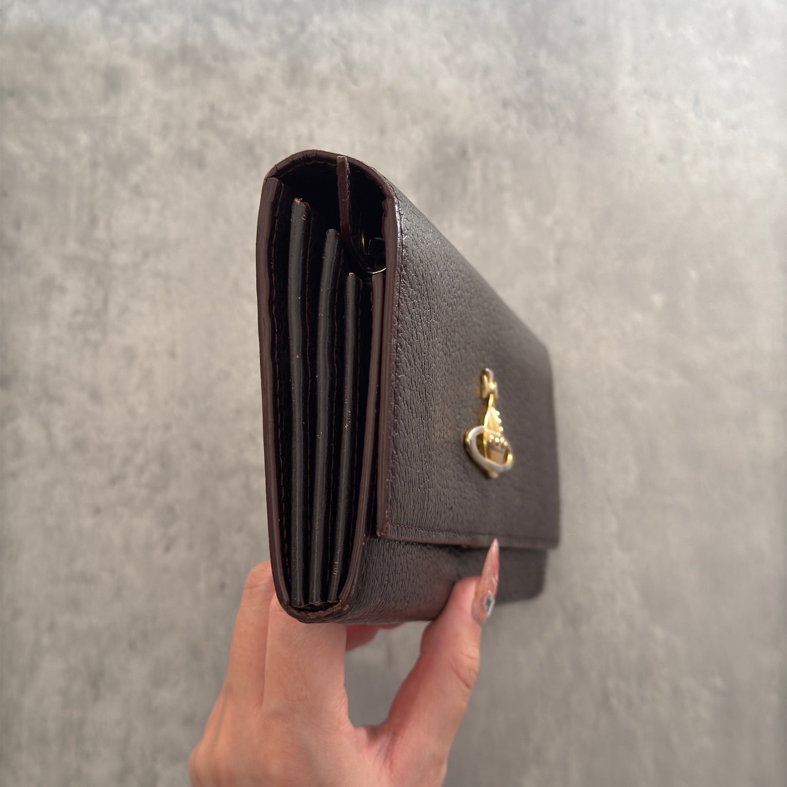 Vivienne Westwood Signature Orb Bi-fold Long Wallet in Black Leather with Gold-Tone Hardware and Multiple Interior Compartments.