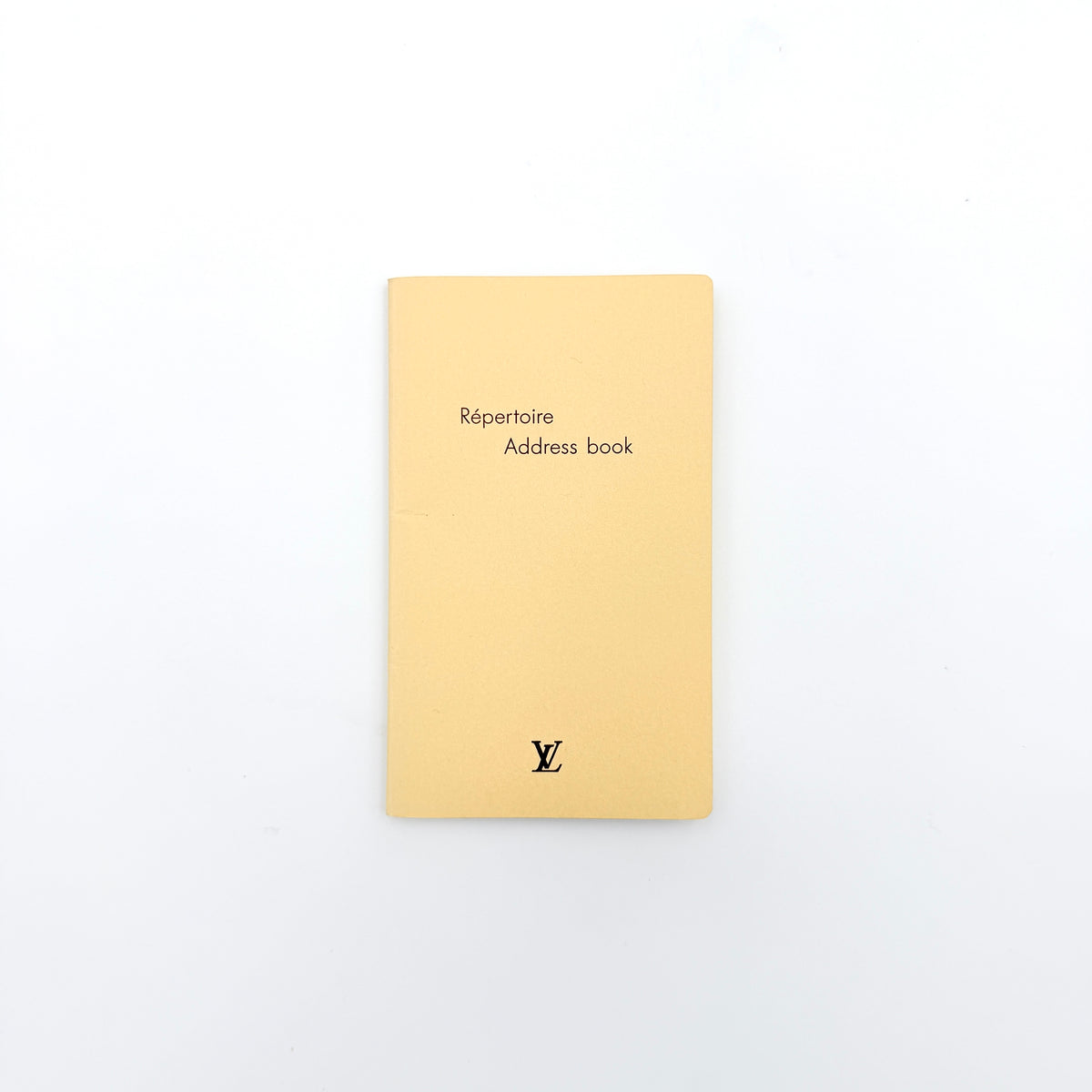 Louis Vuitton Répertoire Address Book in cream with black logo, displayed on a clean white background.