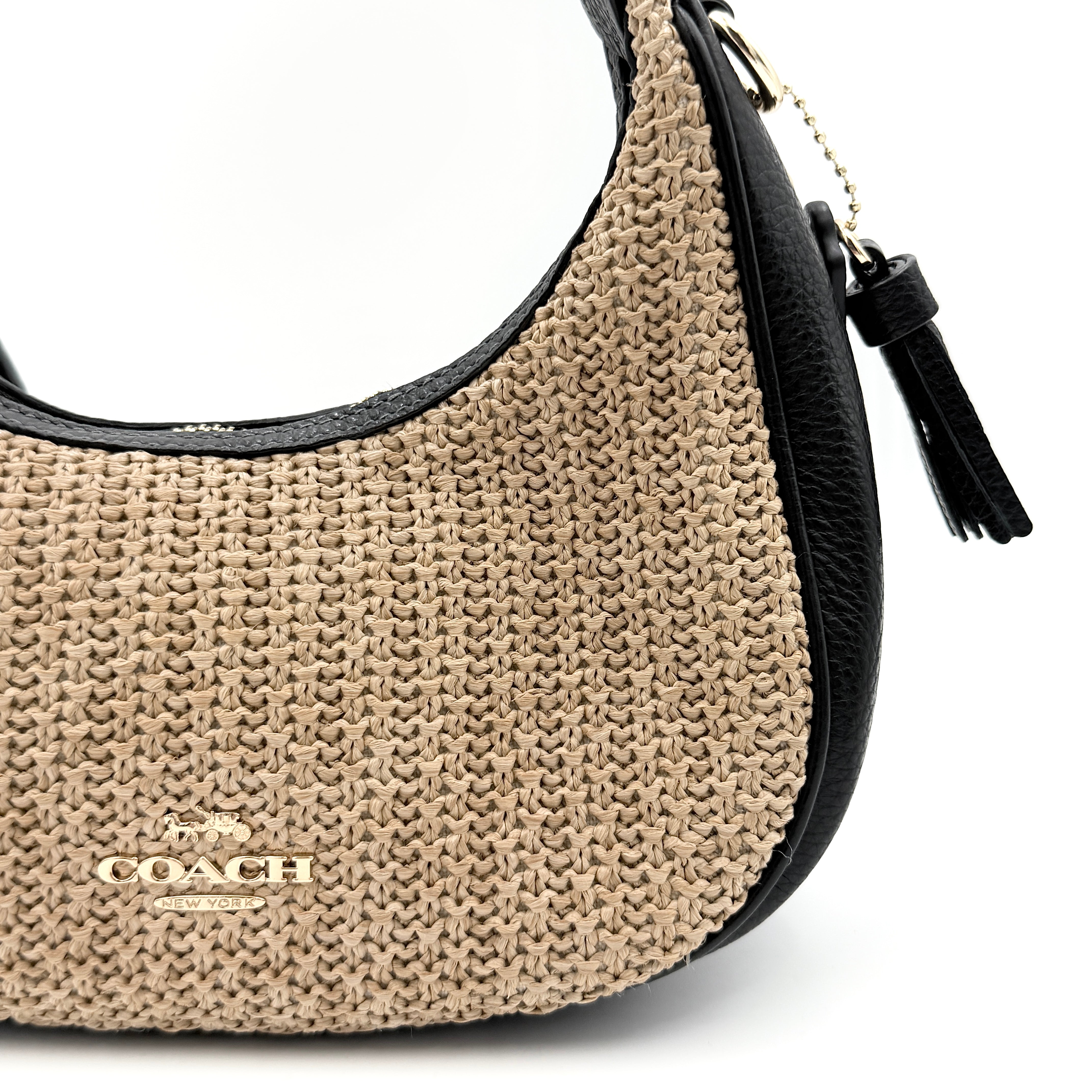 Coach Carmen Mini 2Way Shoulder Bag in beige and black with textured woven body, leather trim, and gold-tone hardware.