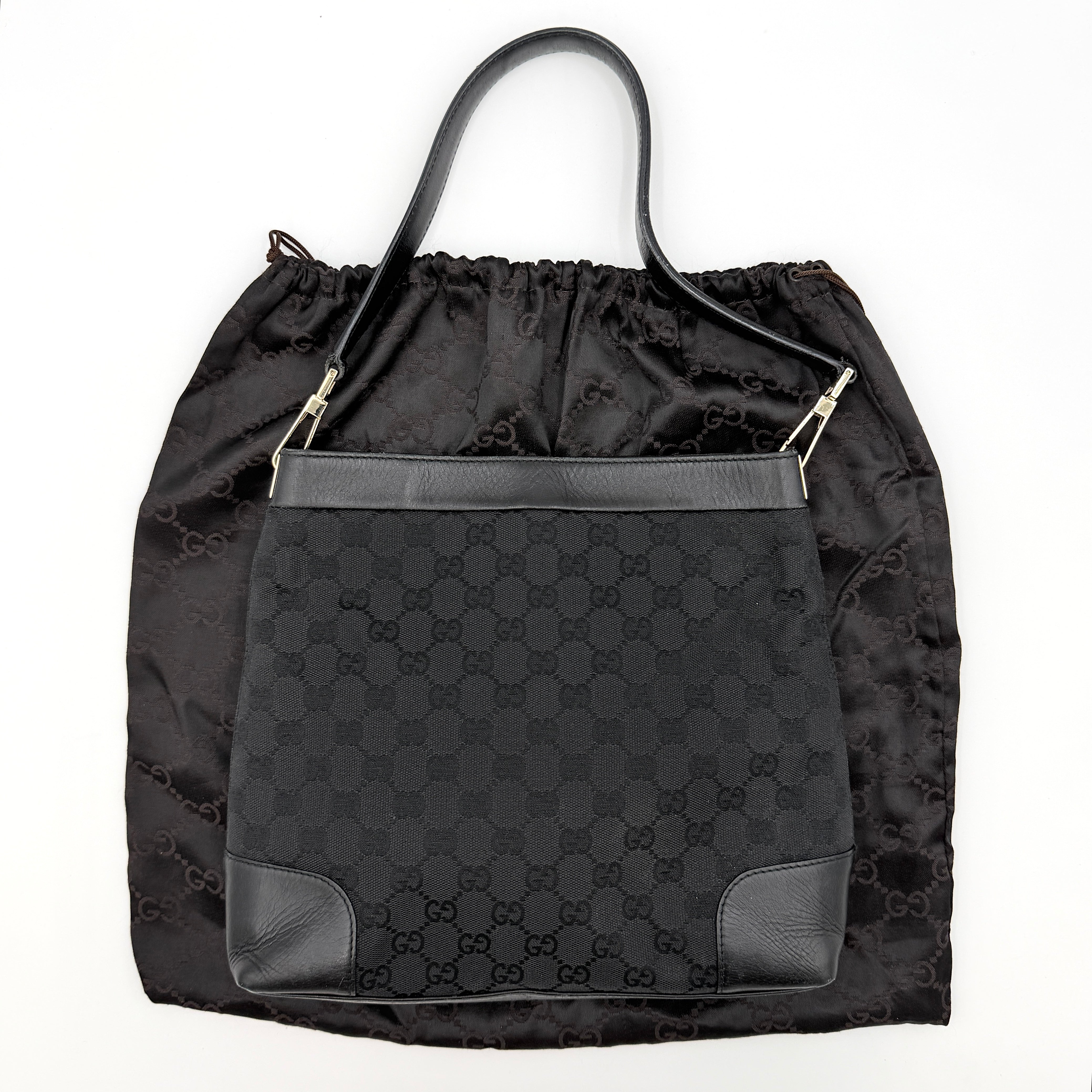 Gucci GG Monogram Bucket Shoulder Bag in black canvas and leather with silver-tone hardware, shown on a white background.